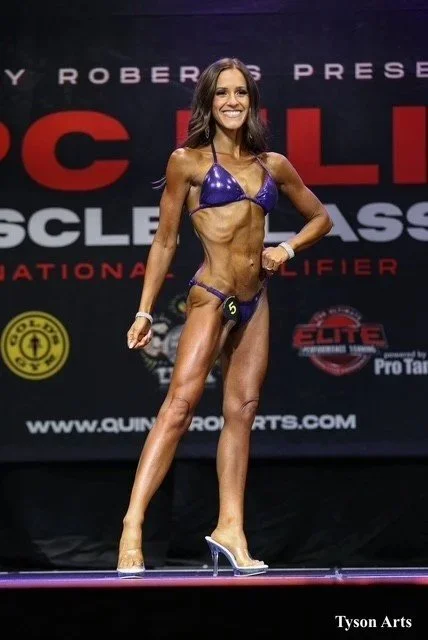 Gabi competing in NPC Fit model while coaching with Stephen Beaugrand and Team Awkward