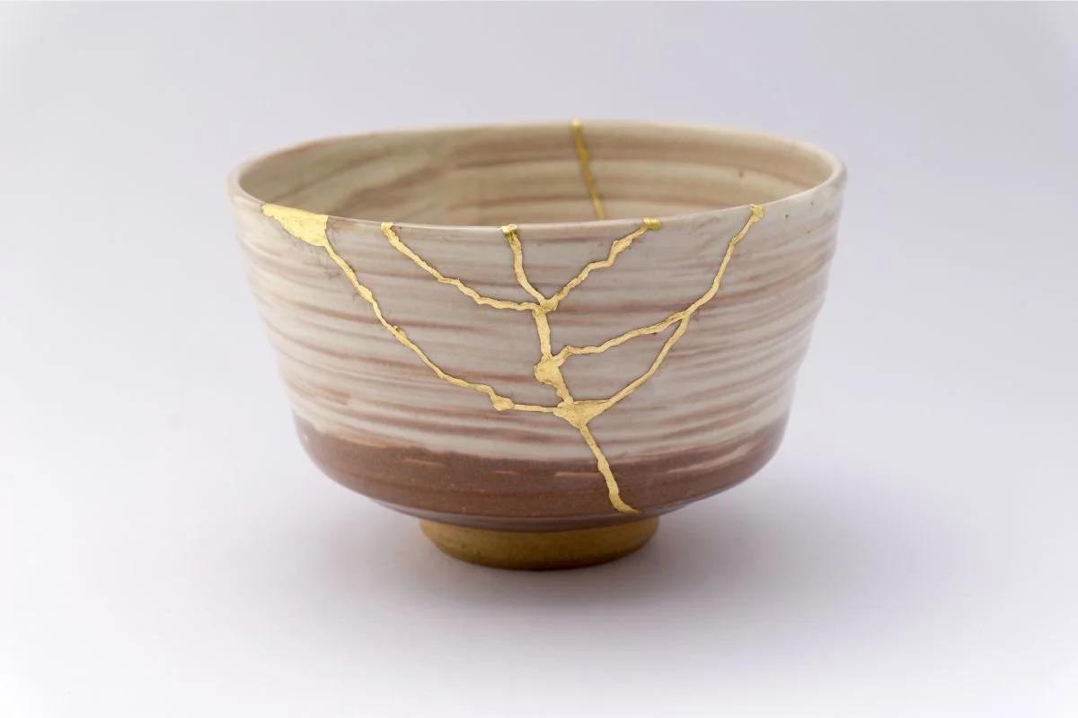 A ceramic bowl repaired using the Japanese Kintsugi method with visible gold seams, symbolizing resilience, healing, and the spiritual art of setting boundaries.