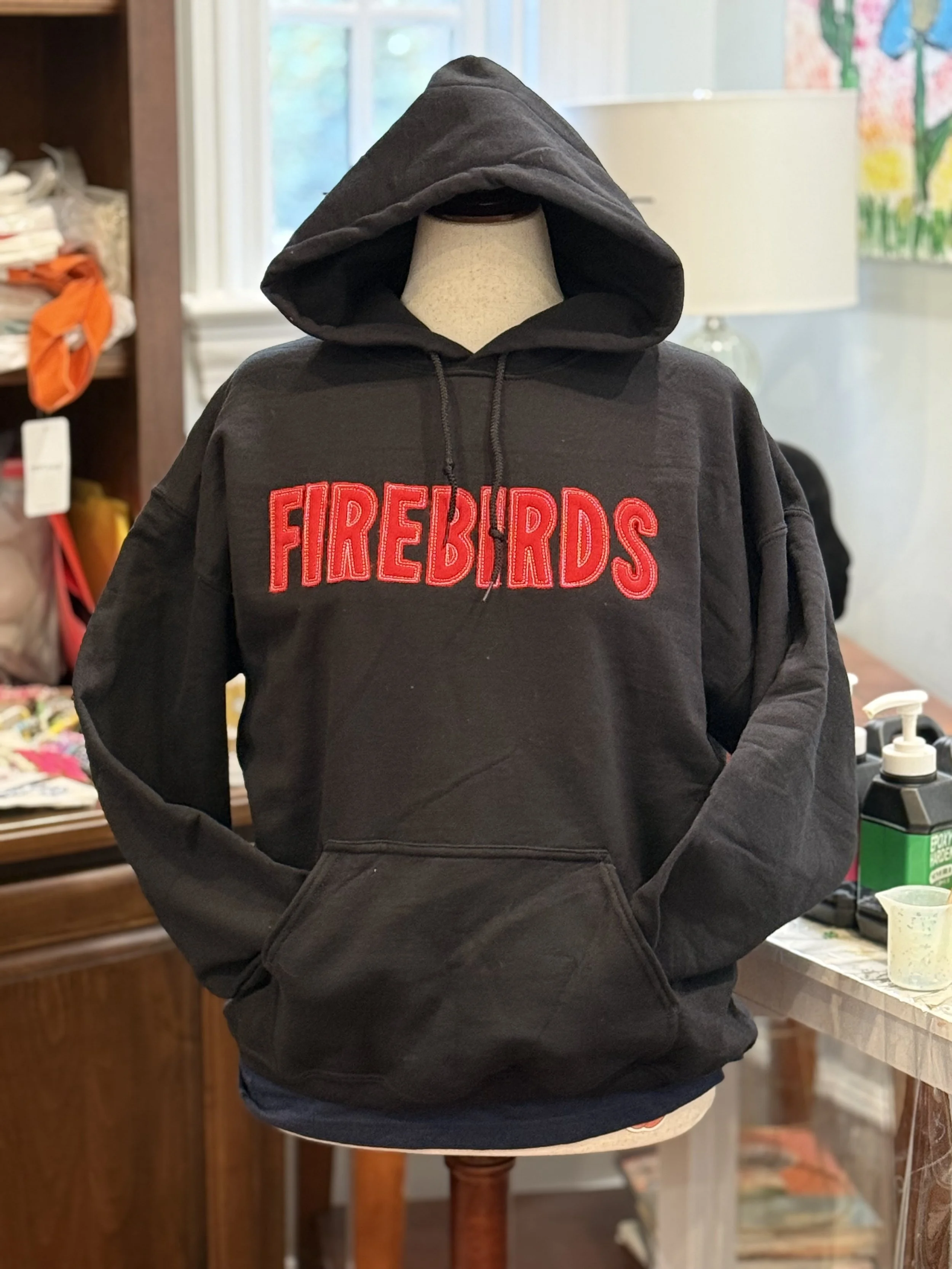 Black Hoodie sweatshirt with the team name, Firebirds, appliqued in red with white stitching.