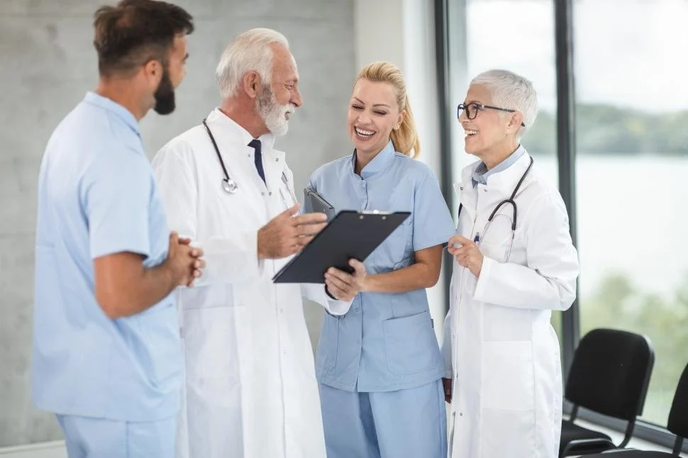 Illustration of diverse medical professionals, including doctors and nurses, standing together in scrubs and lab coats.