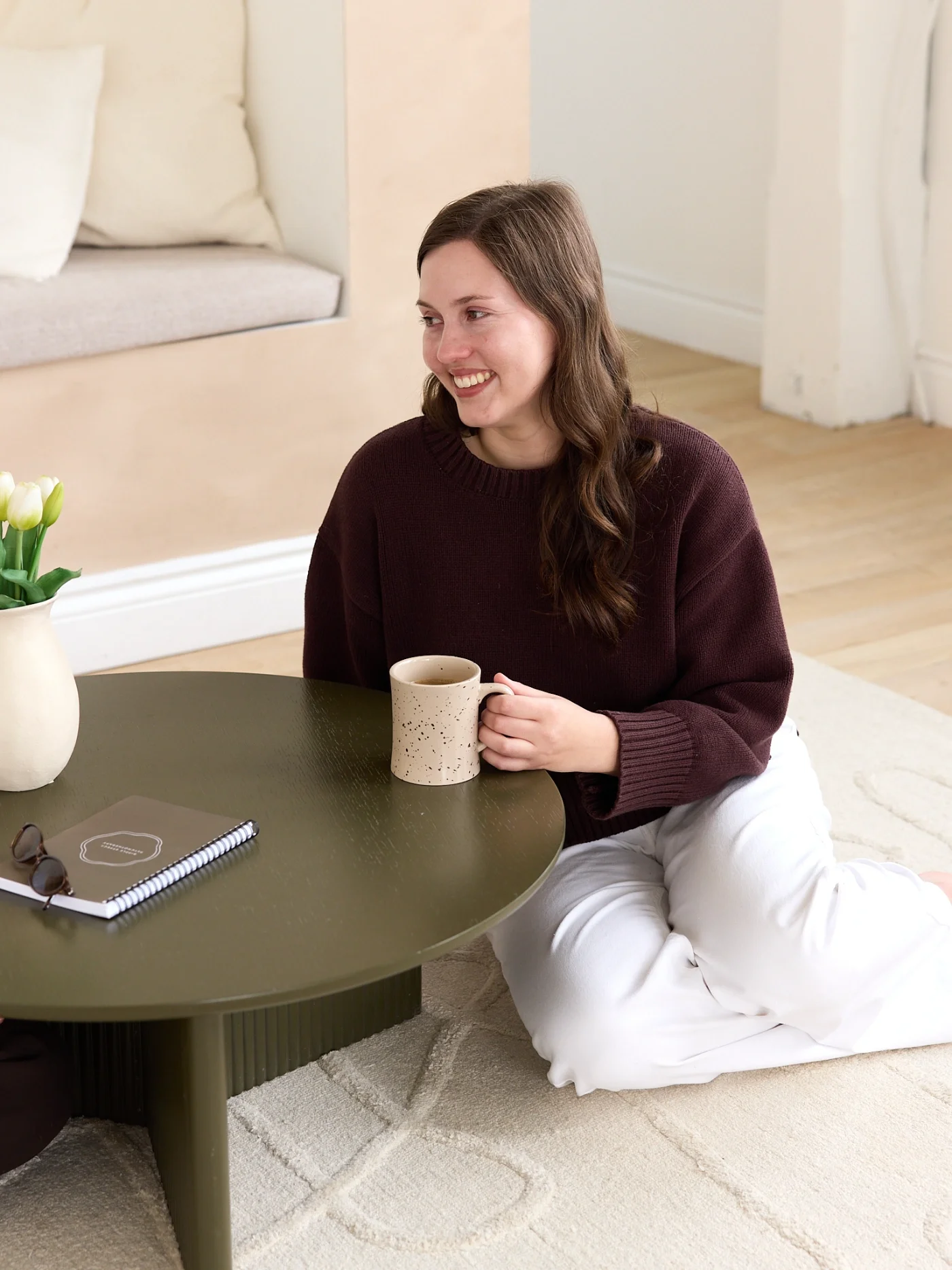 Therapist sitting on floor with a cup of coffee and 'ripple effect' journal