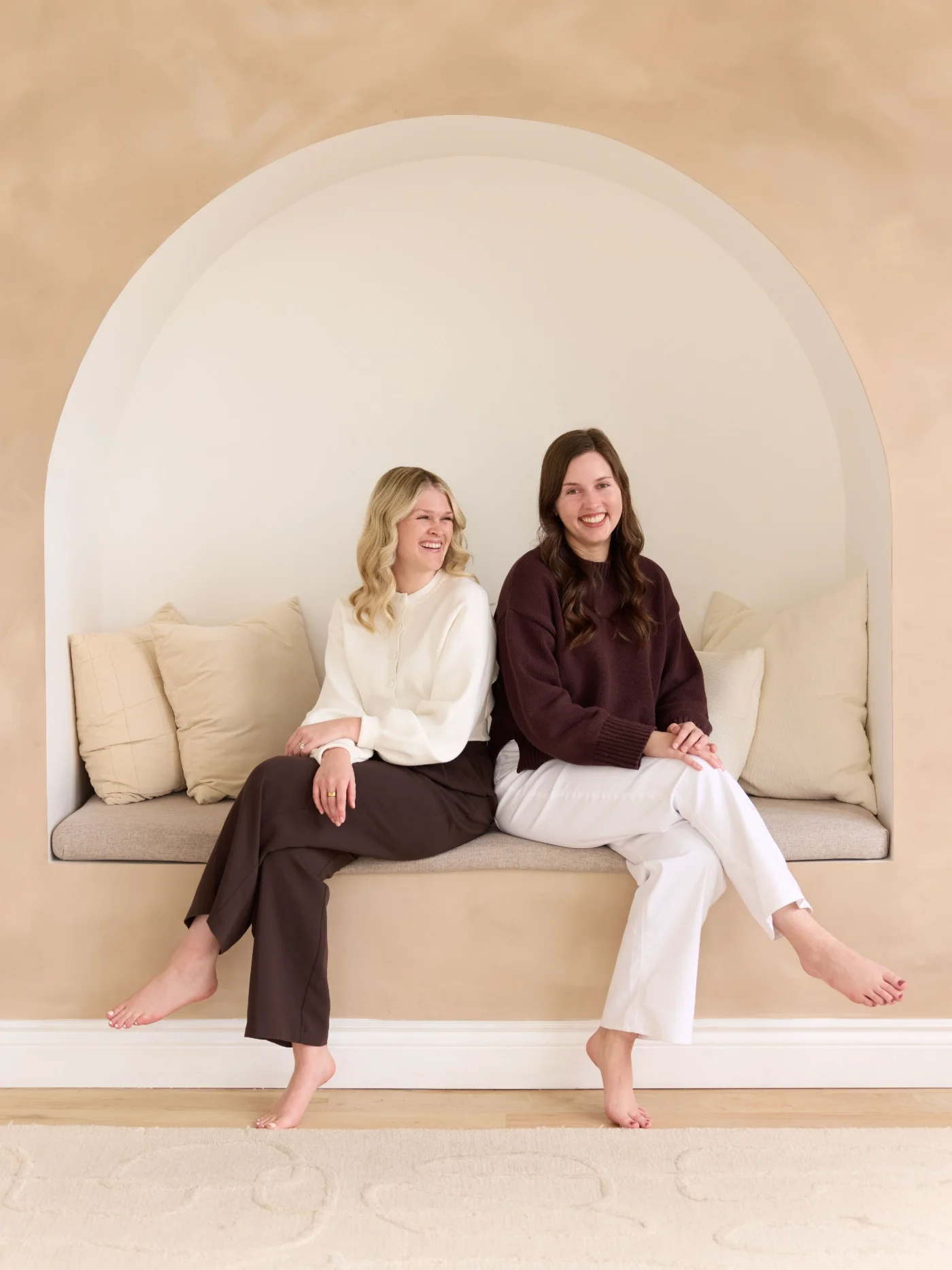 Two ripple Effect therapists sitting on a bench and smiling at the camera.
