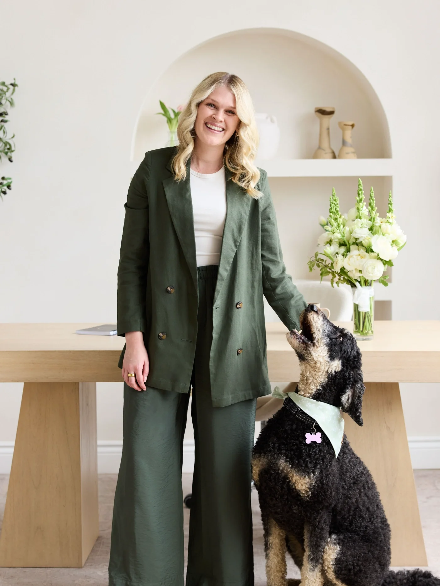 Ripple Effect Therapist Katelyn with her dog Bailey leaning against a desk with flowers.