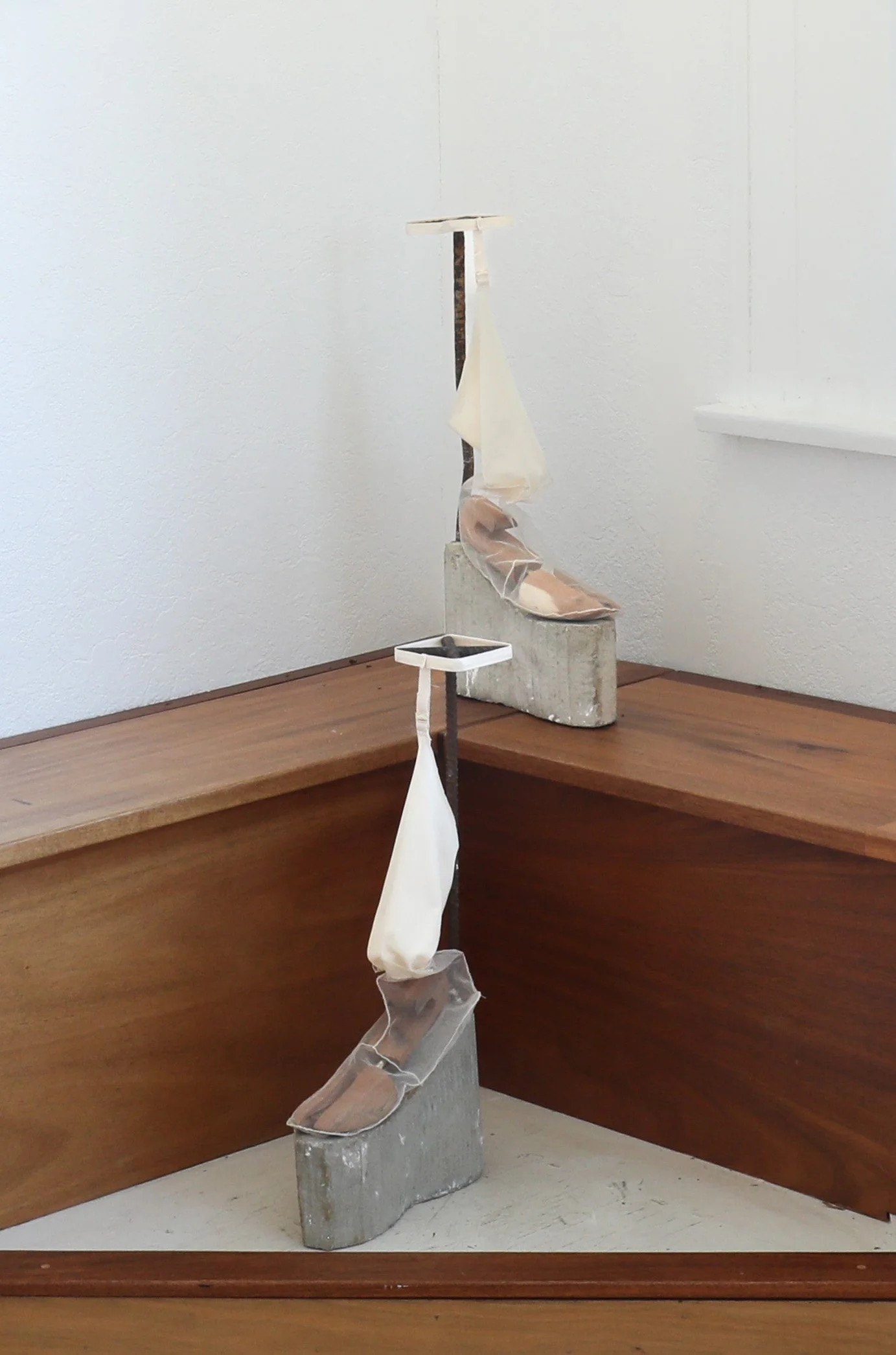A prayer for garters, a curse for heels, R 21.5" x 4.5" x 13" L 20" x 4.5" x 13", cement, structure rods, mesh, nylon, india ink, white thread, and men’s shoe trees