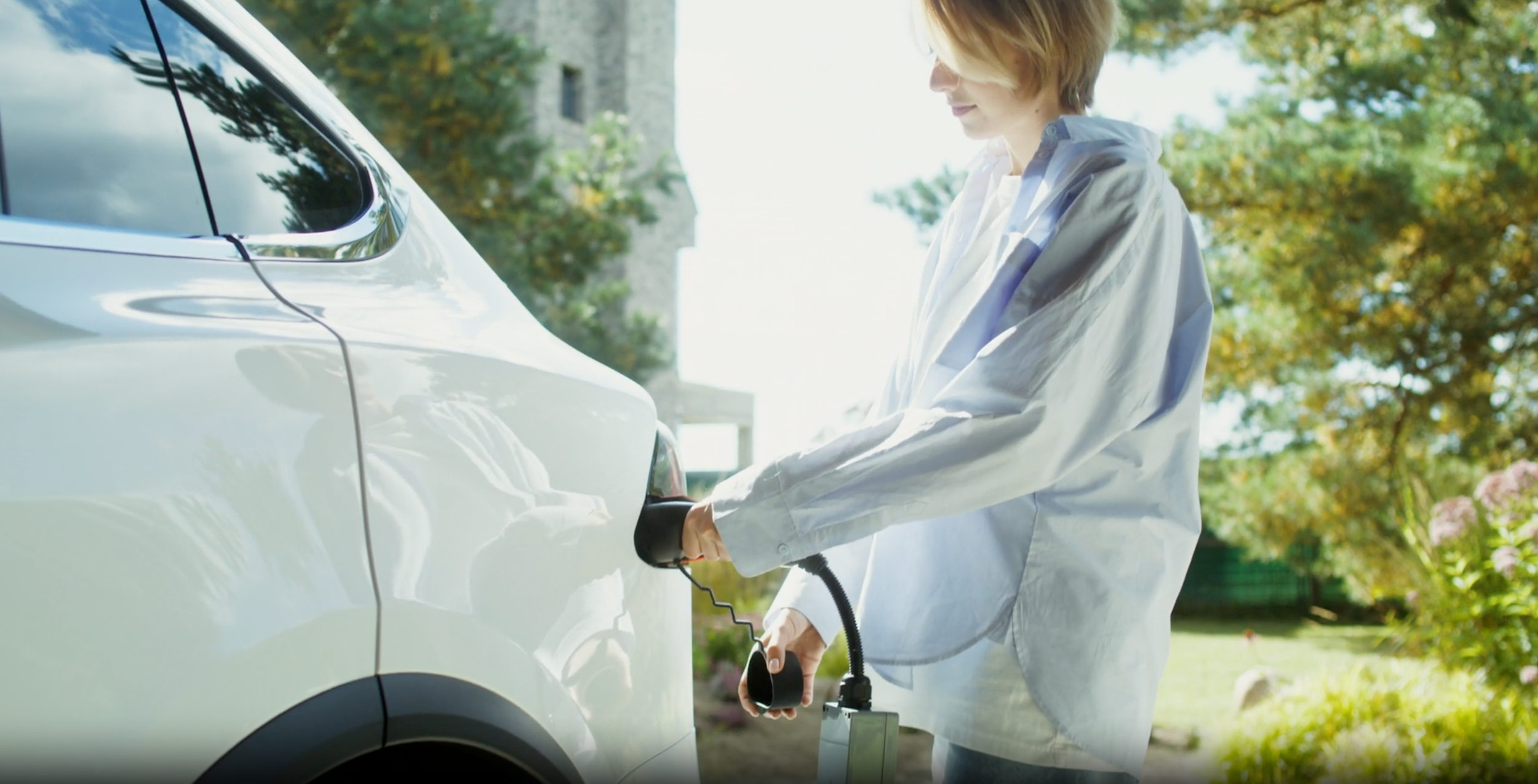Woman charging an electric vehicle