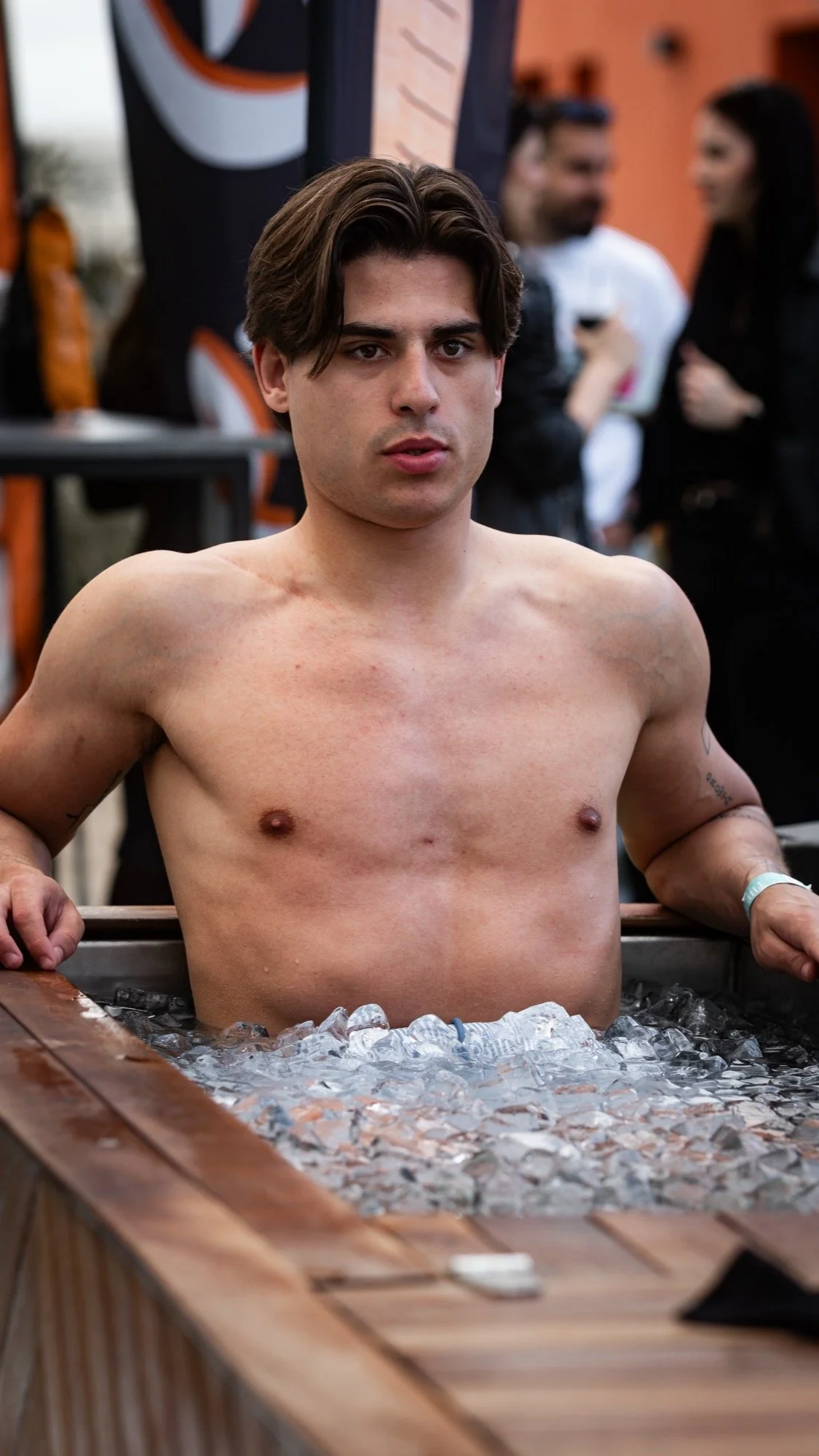 Athlete sitting in an ice bath filled with ice after training