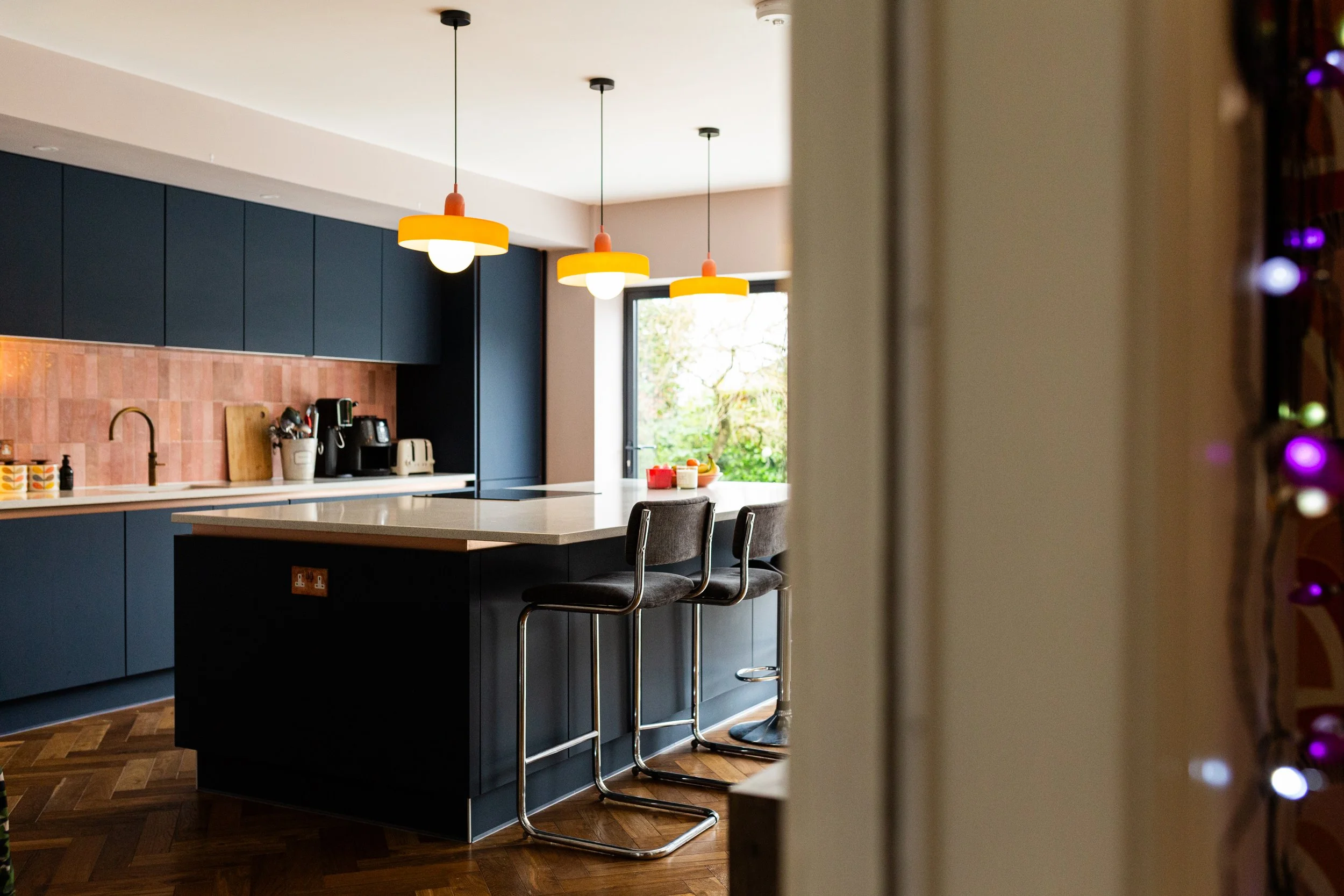 Open plan kitchen dining living extension. Orange statement lighting. Blue kitchen