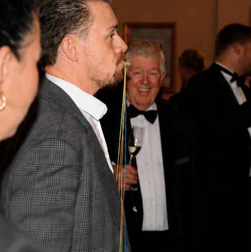 Just Saul chatting with a guest in formal attire at a black-tie corporate event