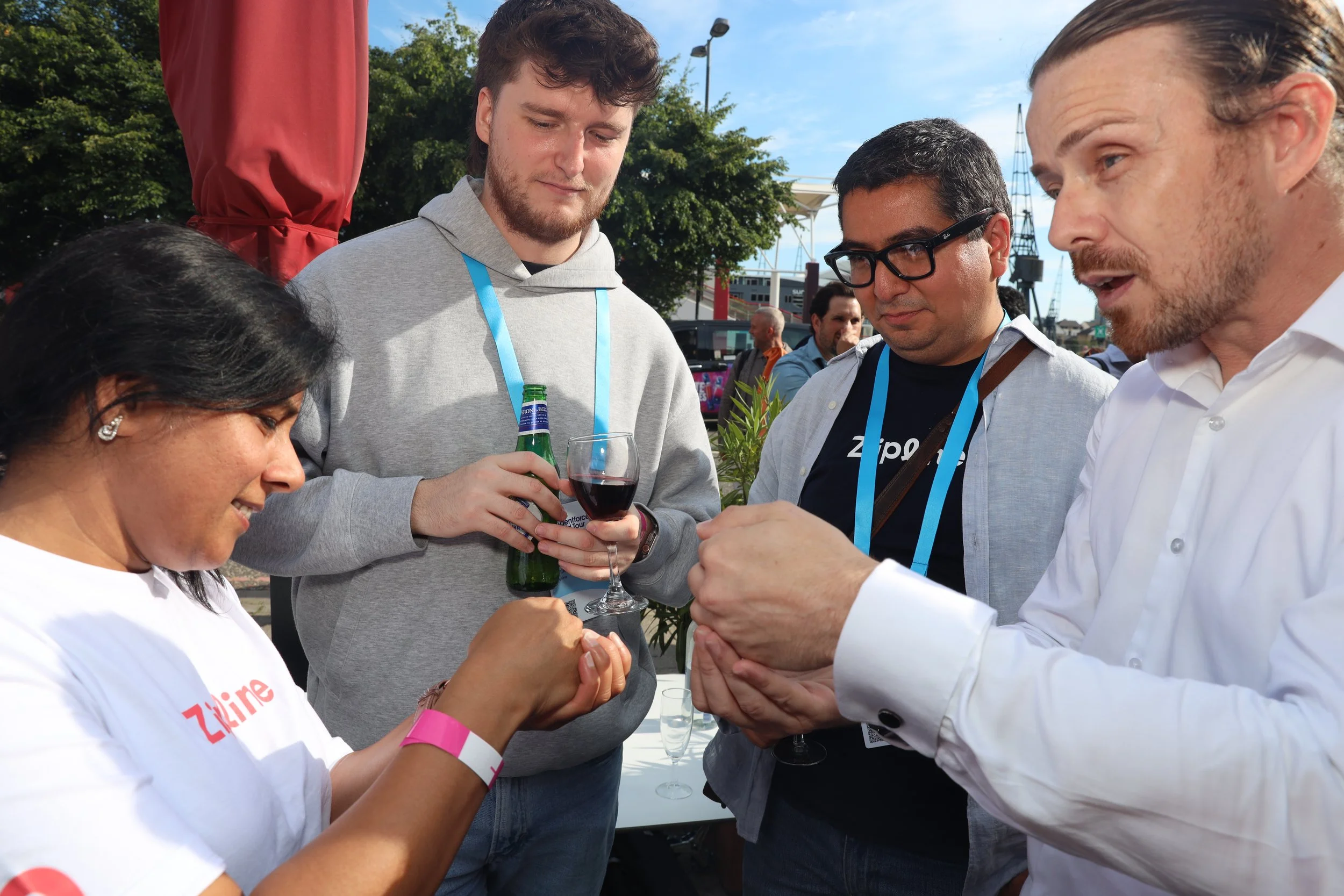 Just Saul performing close-up magic for a small group of corporate event guests outdoors