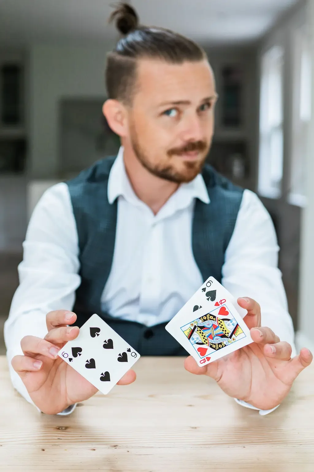 Sussex Magician Just Saul holding two black cards and a queen