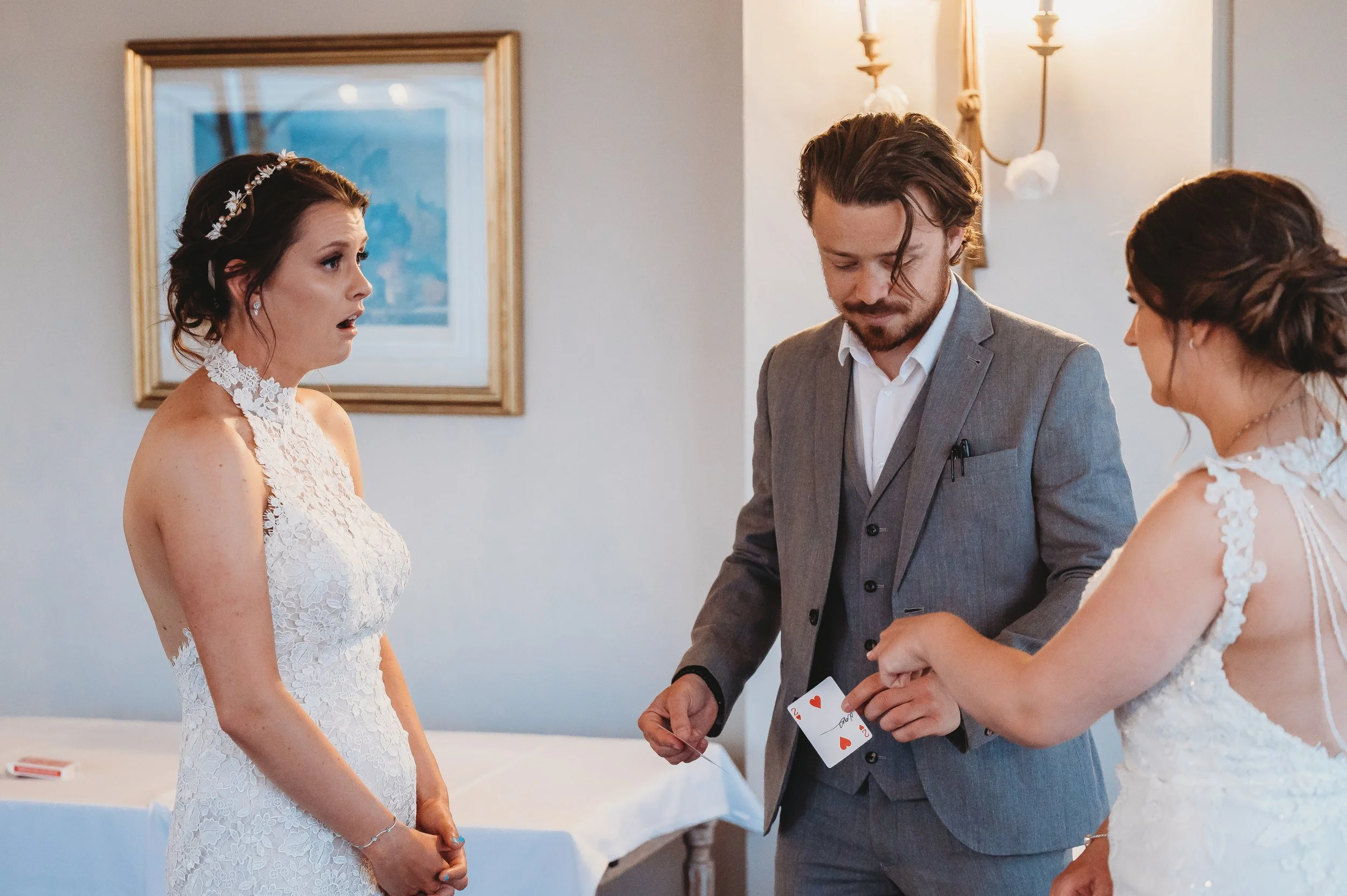 Wedding magician Just Saul performing a card trick for the bride and bridesmaids