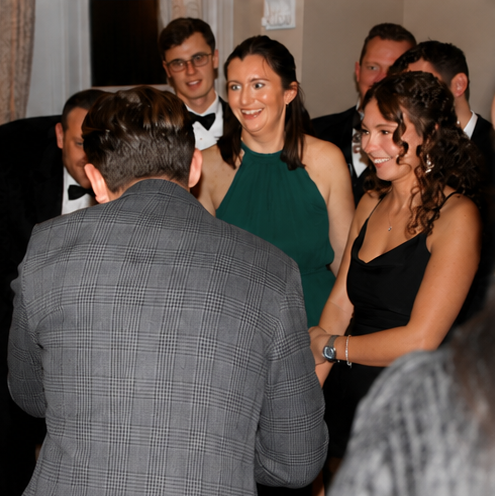 Just Saul chatting with guests in formal attire at a black-tie corporate event
