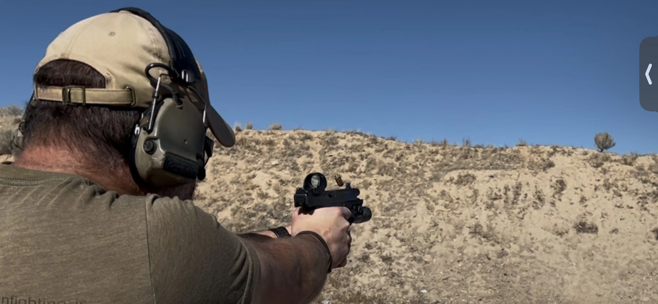 Instructor firing handgun equipped with a Red Dot Sight