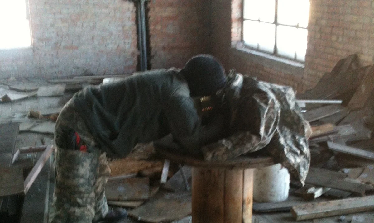 Subject in precision rifle hide in camouflage.