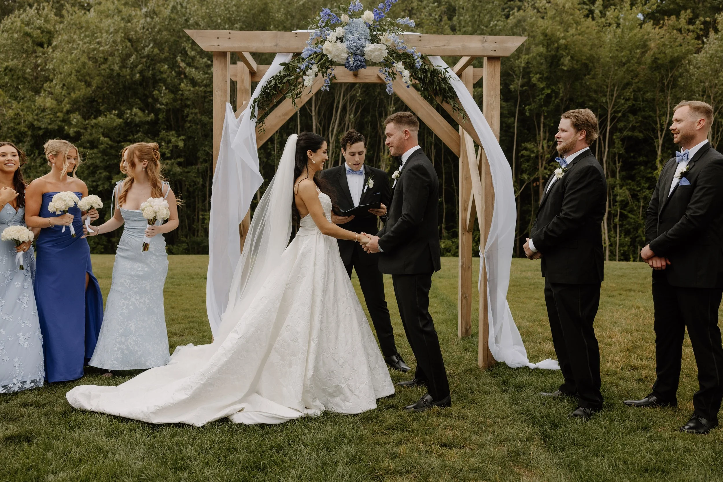 Wedding ceremony on the Middle Lawn with guests facing the back woods. 