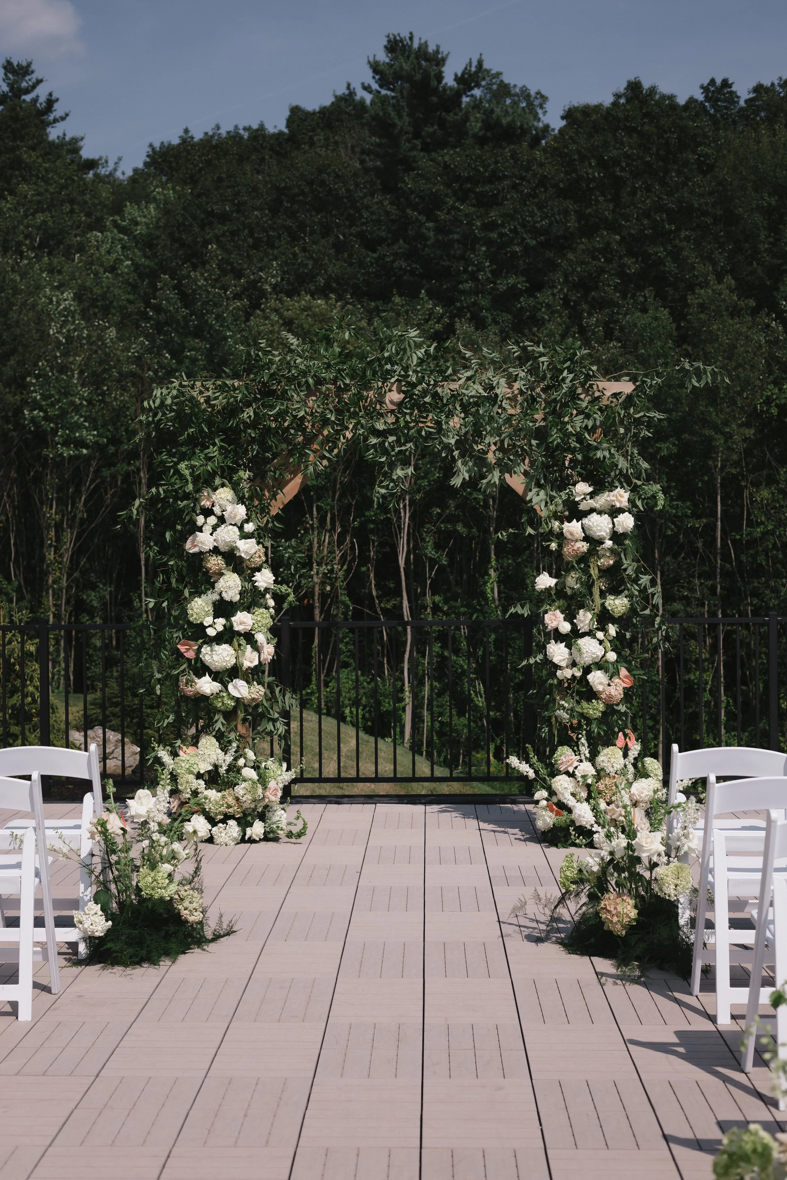 Arch and floral arrangements facing the back woods on the Roof Top Deck. 
