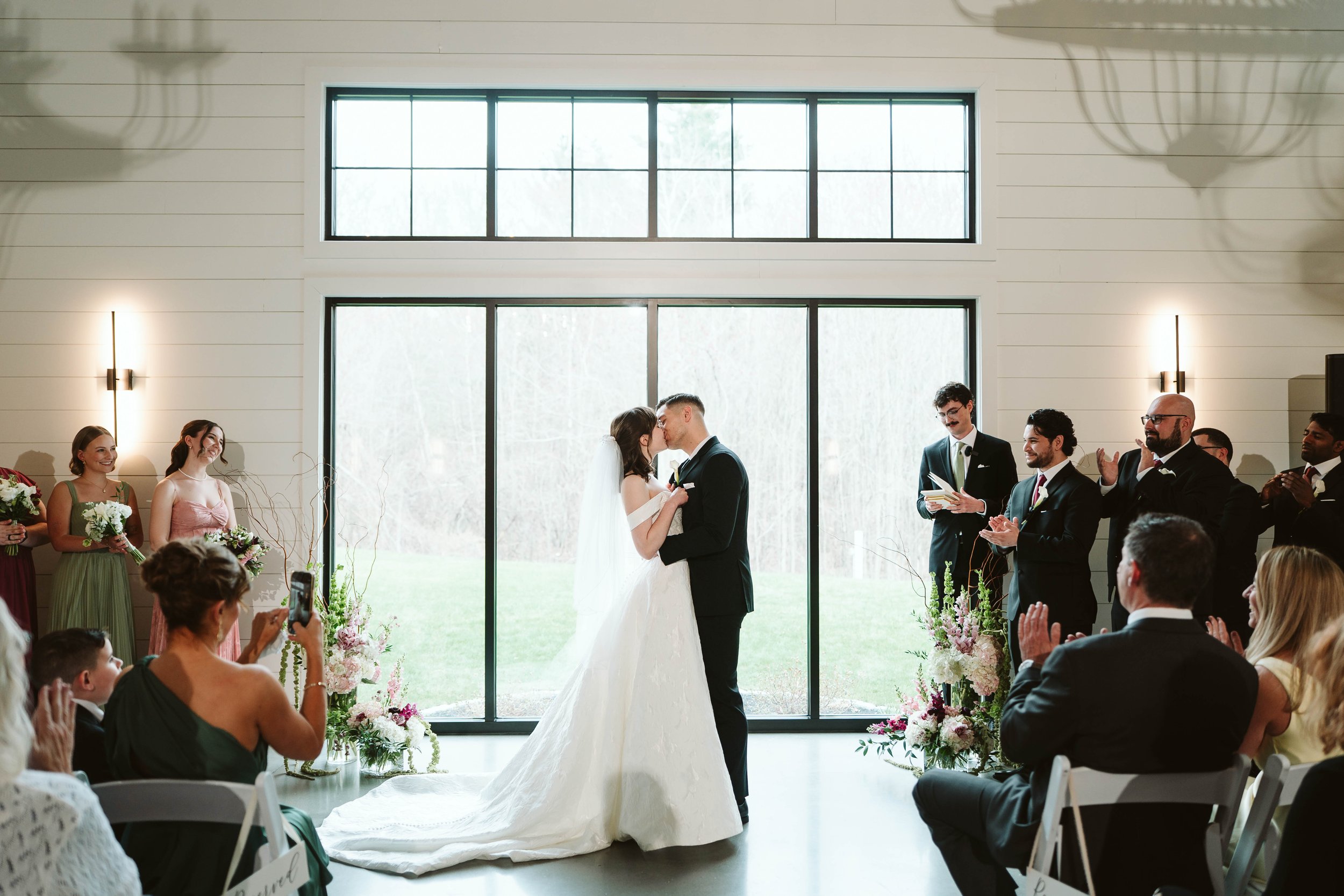 Couple in front of back windows post-ceremony. 