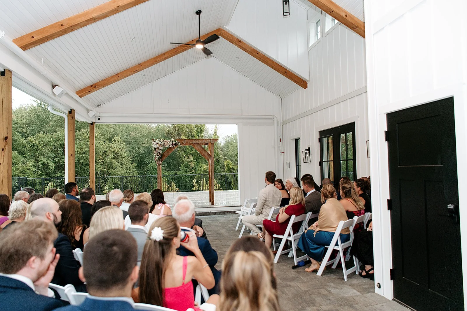 View of wedding ceremony located under the Covered Breezeway from the back left guest seating. 