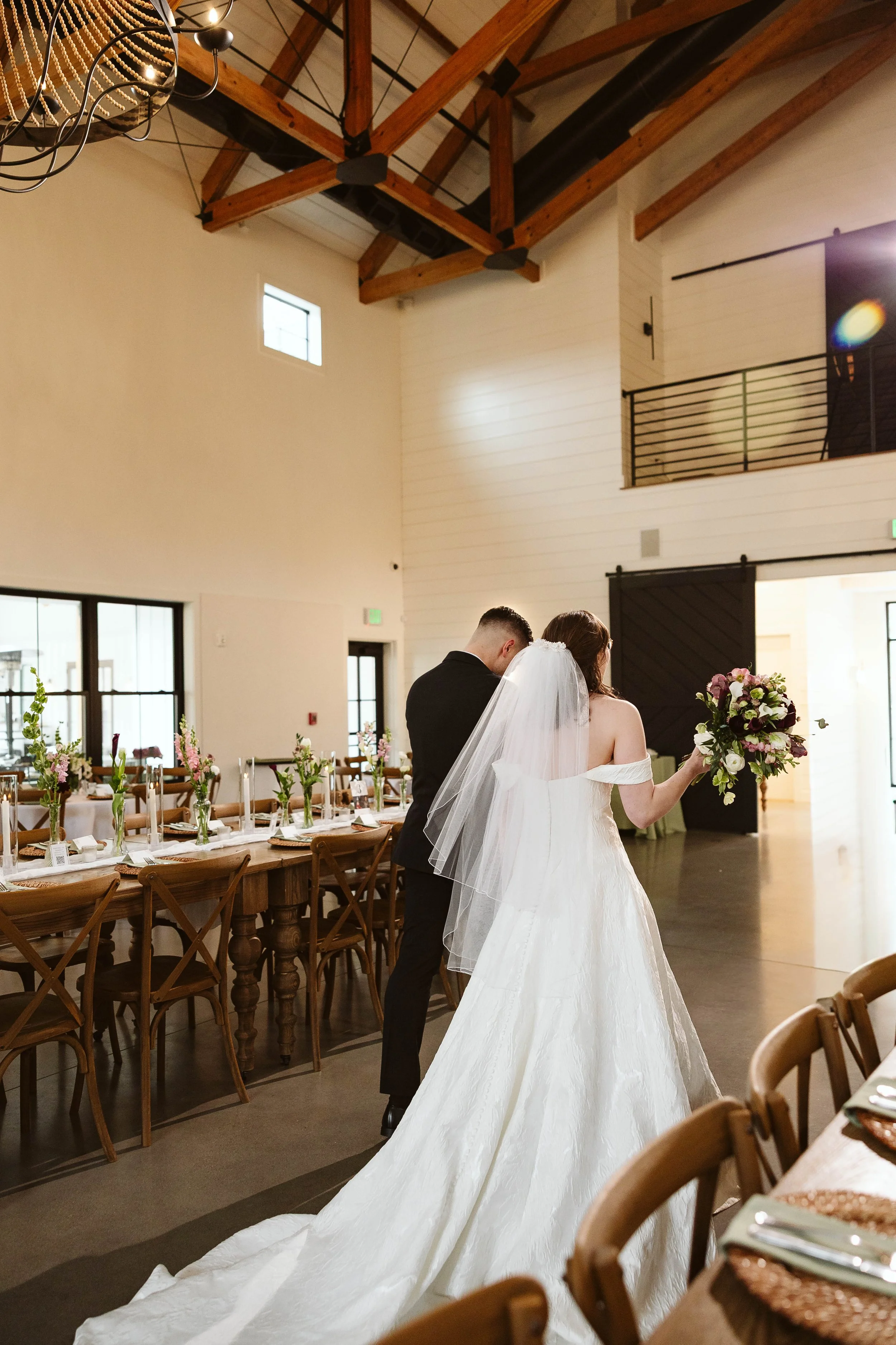 Bride and groom walking down the aisle towards the lobby barn doors.