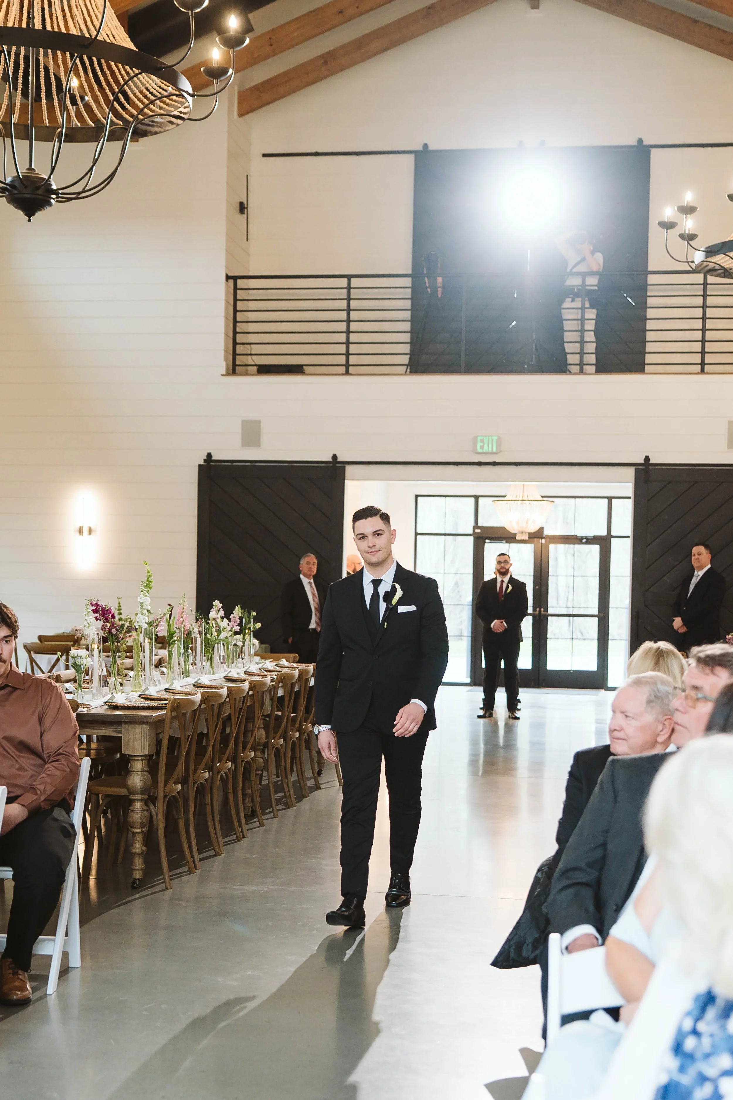 Groom walking down the aisle from the front lobby. 