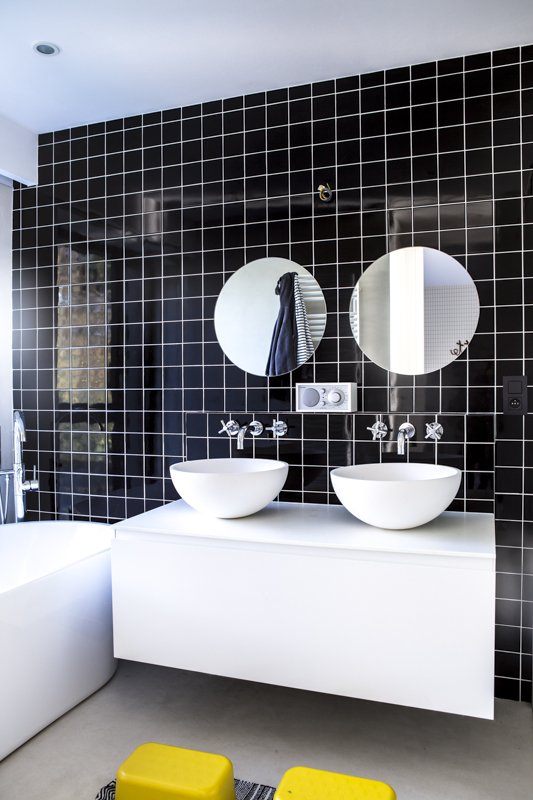  Chez Cristina de Bonjour Georges : salle de bain minimaliste et d’inspiration nordique au carrelage noir et au mobilier blanc.  