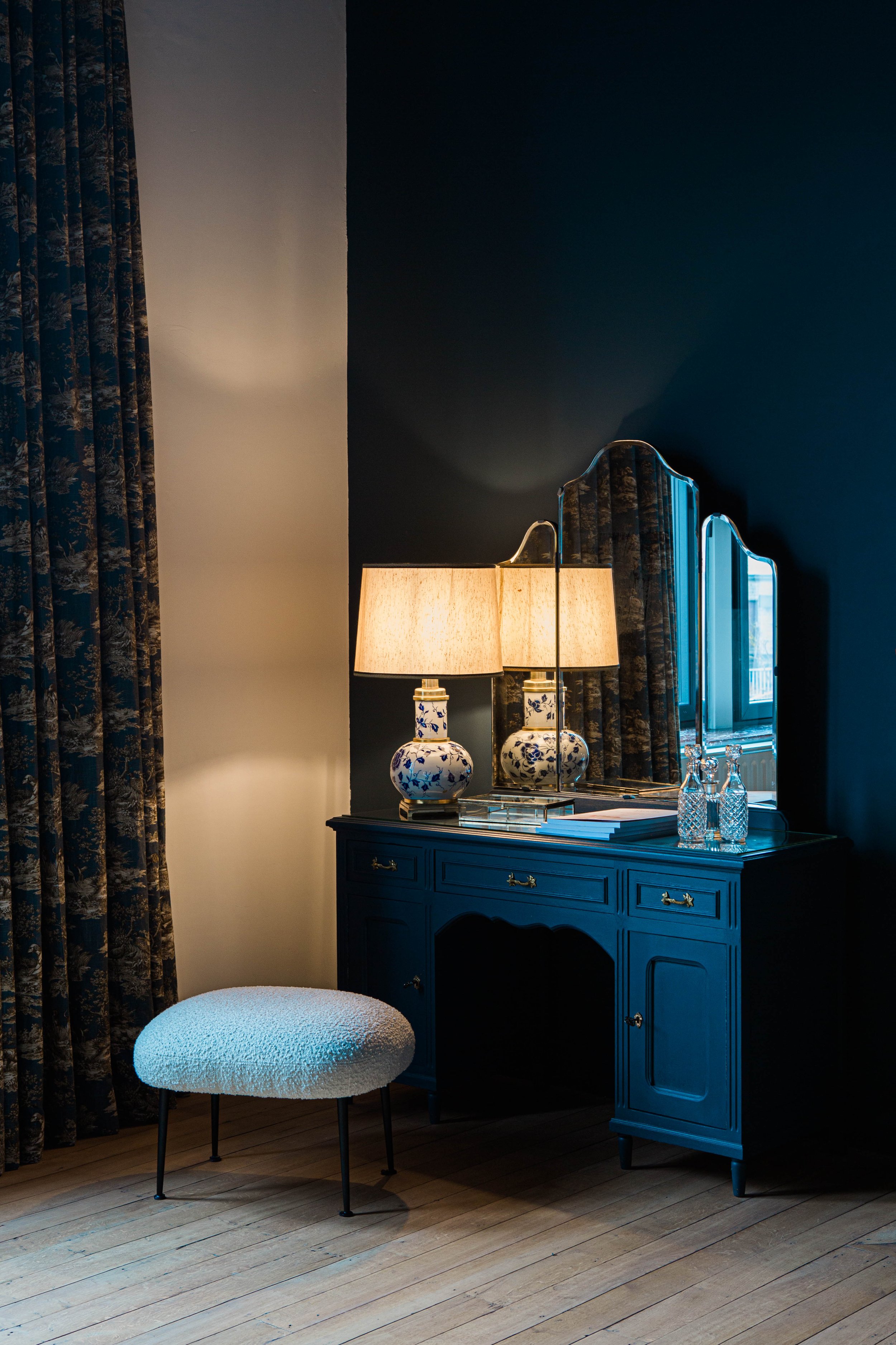  Dans cette chambre d’hôtes, on trouve une chambre au coloris bleu nuit. Le meuble et le miroir anciens ont été chinés.  