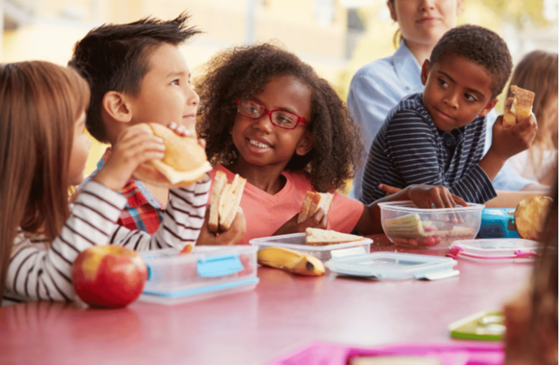 Group of kids eating lunch together to build preschool social skills and independence