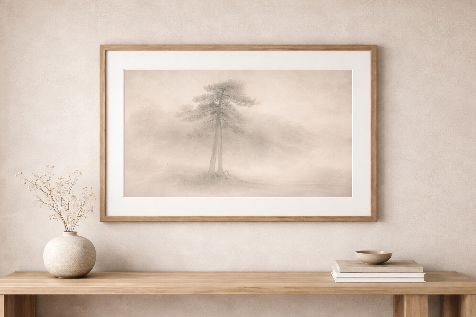 Minimalist interior with a framed monochrome artwork of a tree on the wall above a wooden console, a textured vase with dried branches on the left, and a stack of books with a bowl on top on the right.
