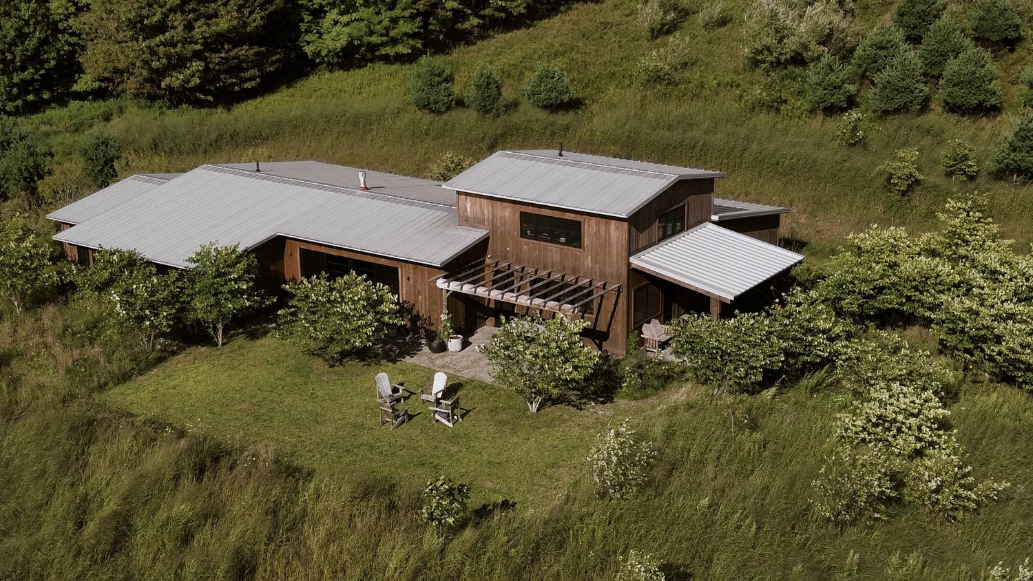 Aerial view of the house and its outbuilding among meadow and young woods