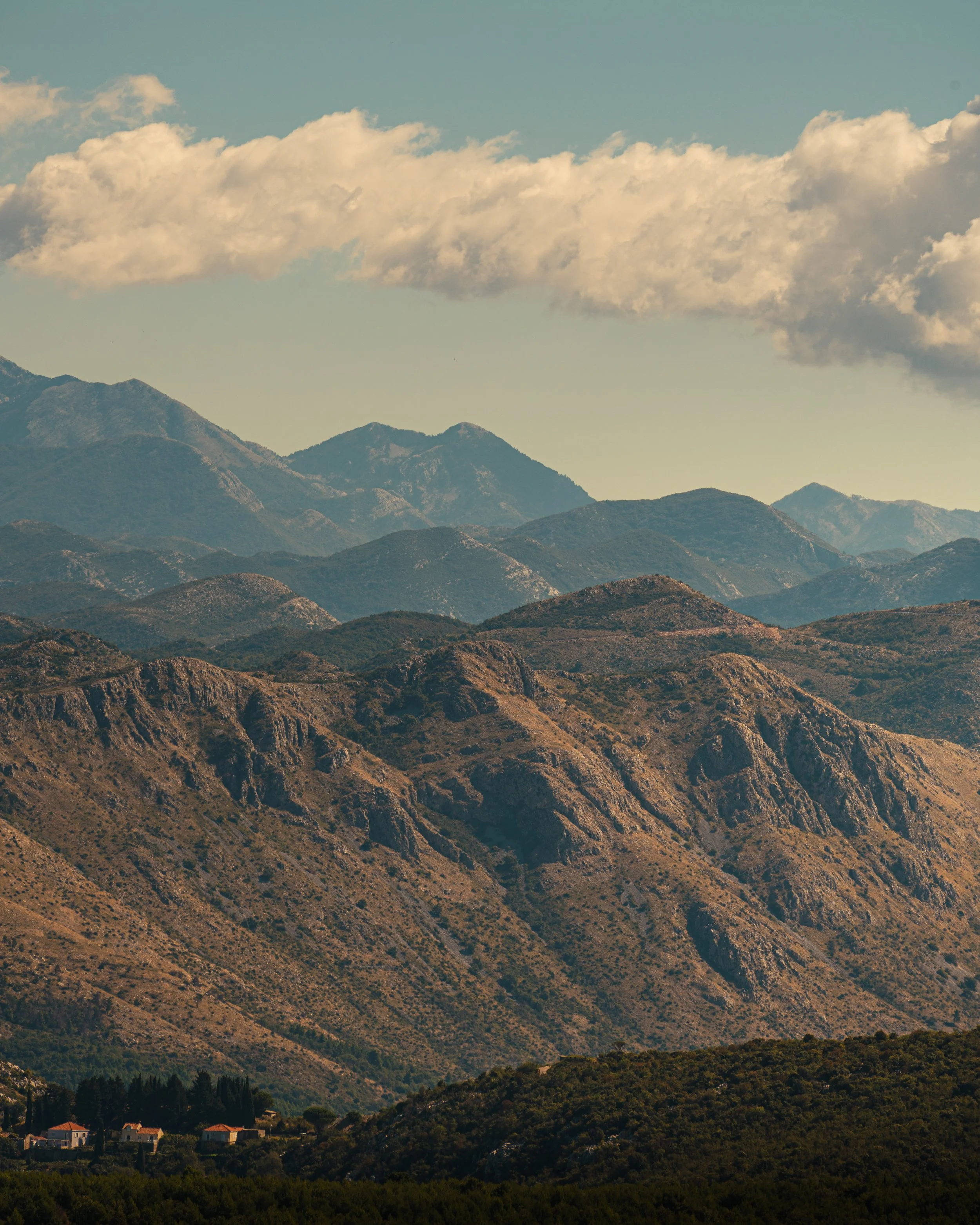 Scenic view of mountains with multiple layers of ridges, under a partly cloudy sky.