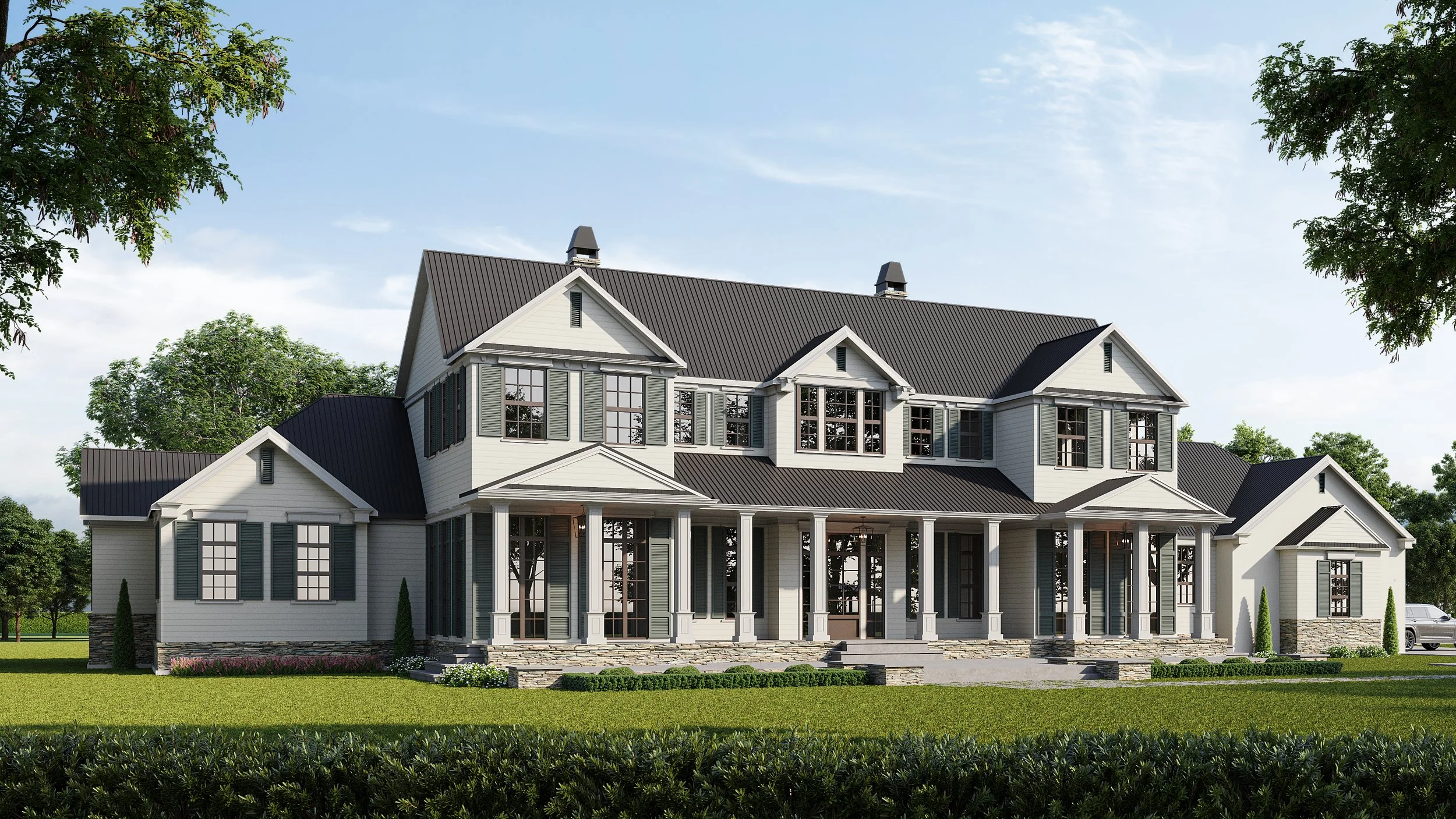 Large two-story Low Country style house with white siding, dark roof, many windows, front porch, surrounded by green lawn and trees.