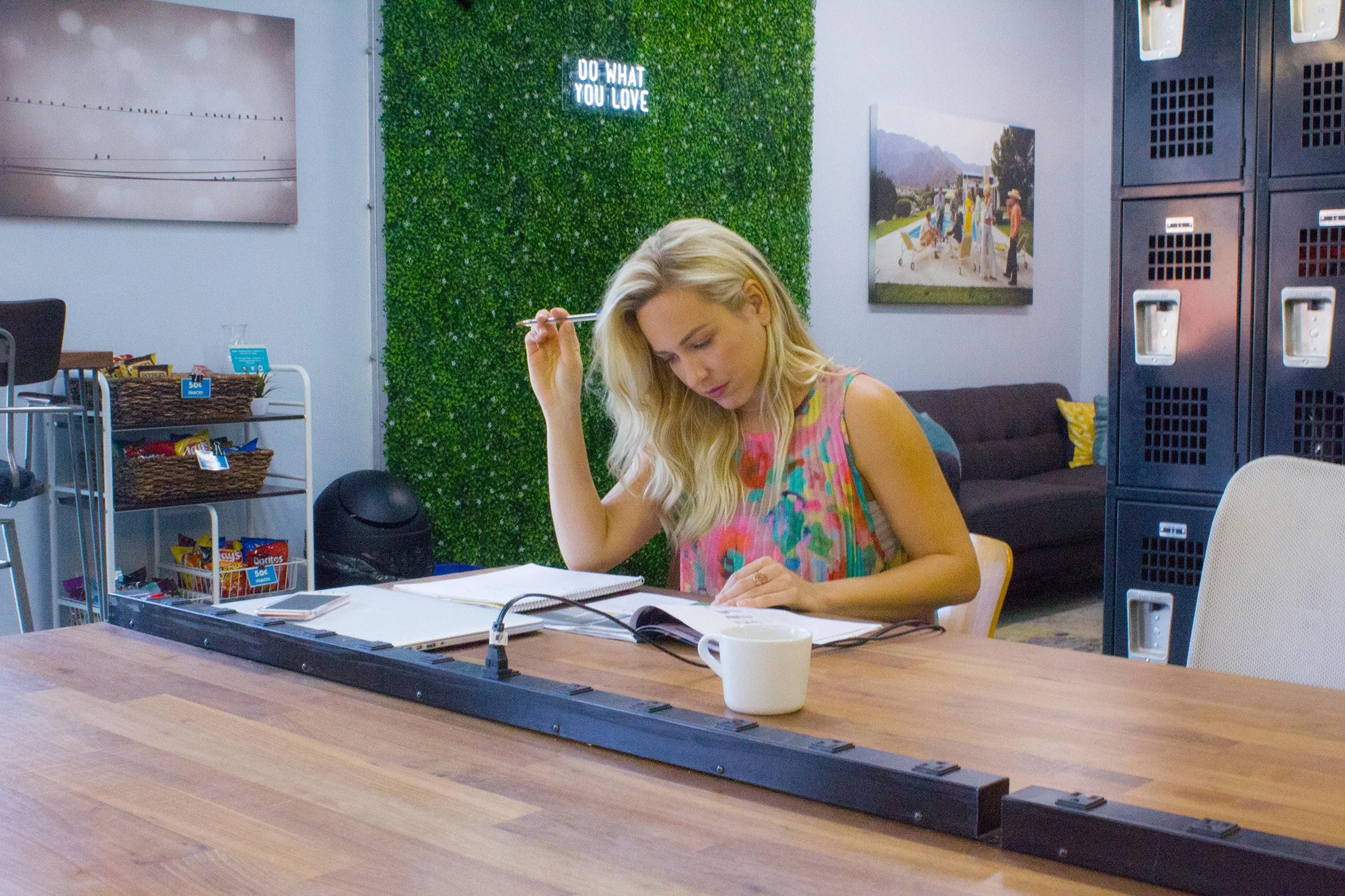Woman at coworking space, Createscape, in east Austin working and studying at open desk seating.