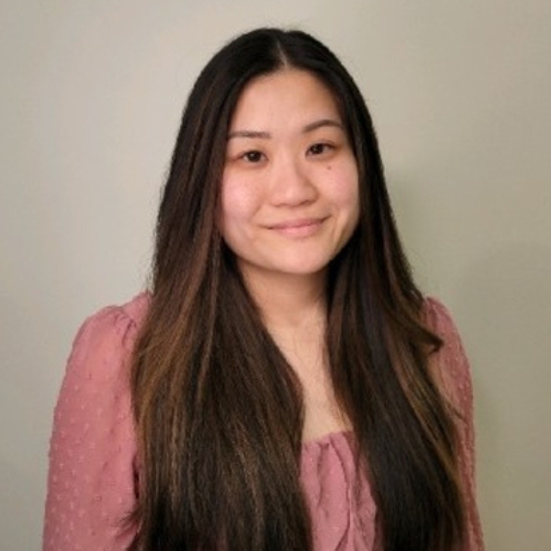 Minna, an Asian person with long dark hair wearing a pink blouse.