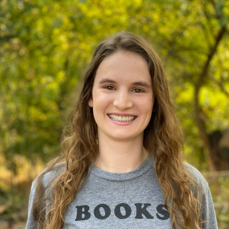 Richelle Braswell, a white person with long wavy hair smiling outdoors.