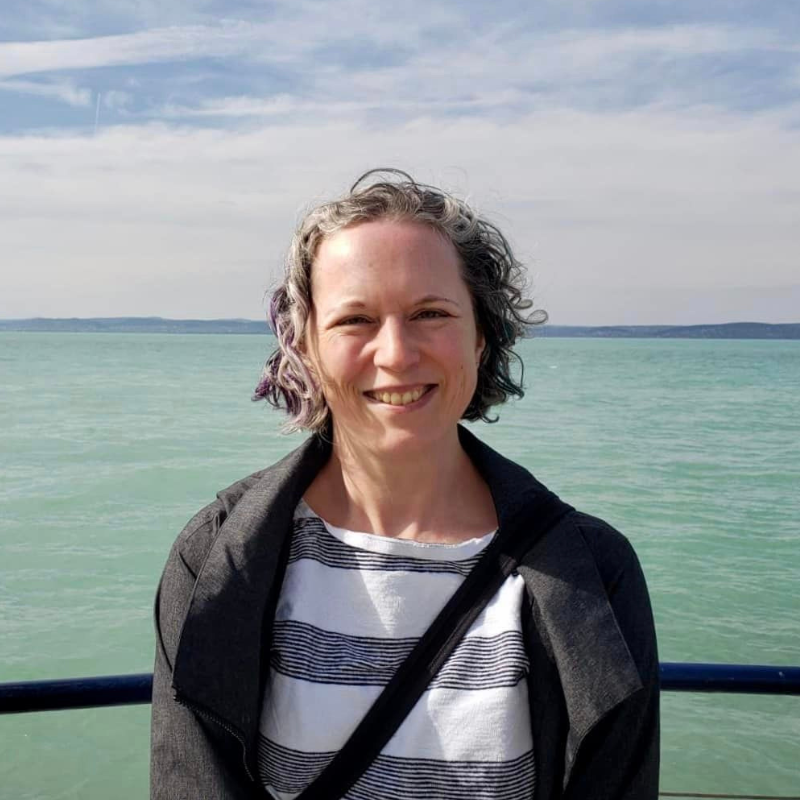 Cath Ennis, a white person with short curly hair standing outdoors
