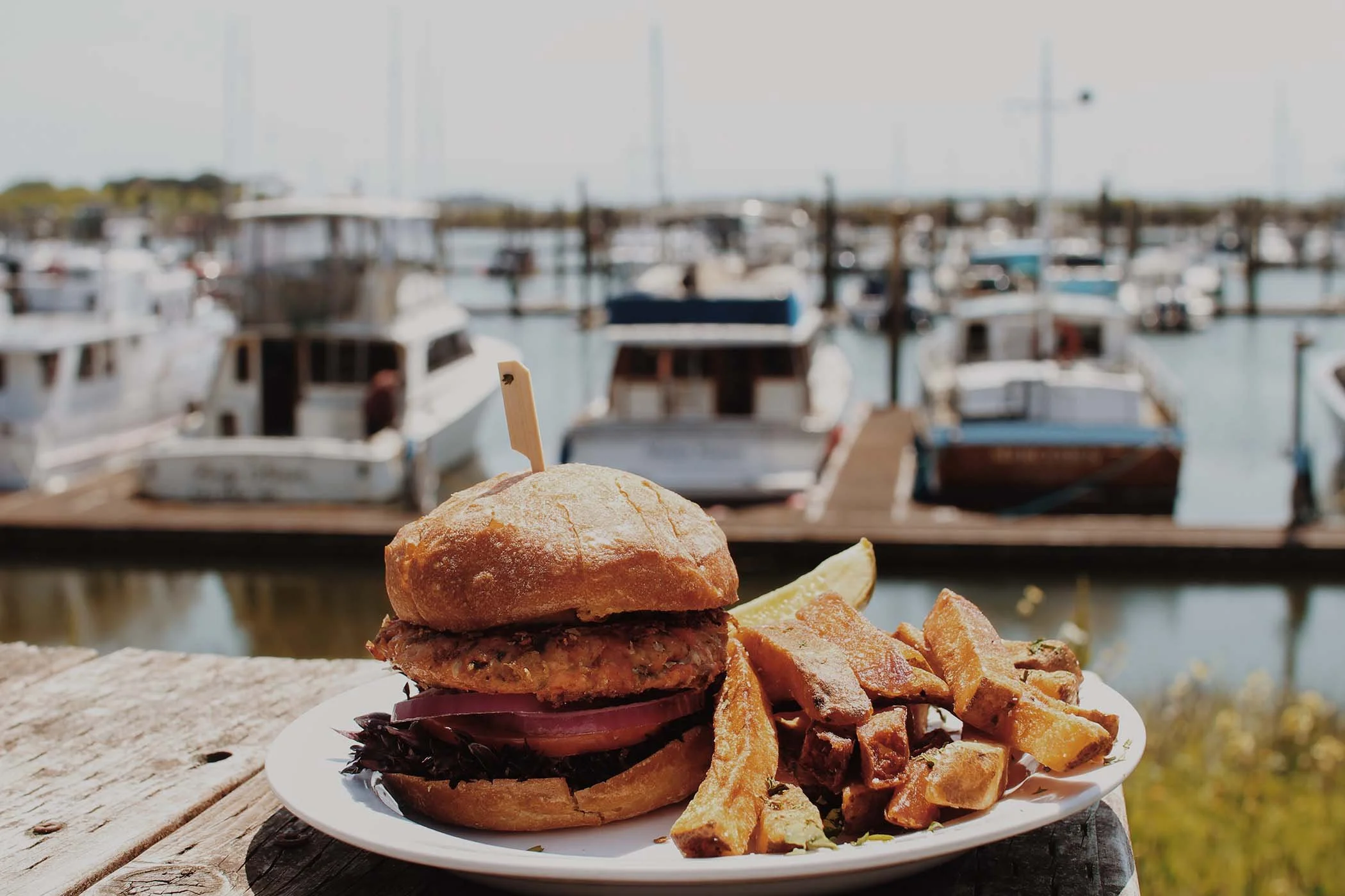 burger and fries with view of harbor