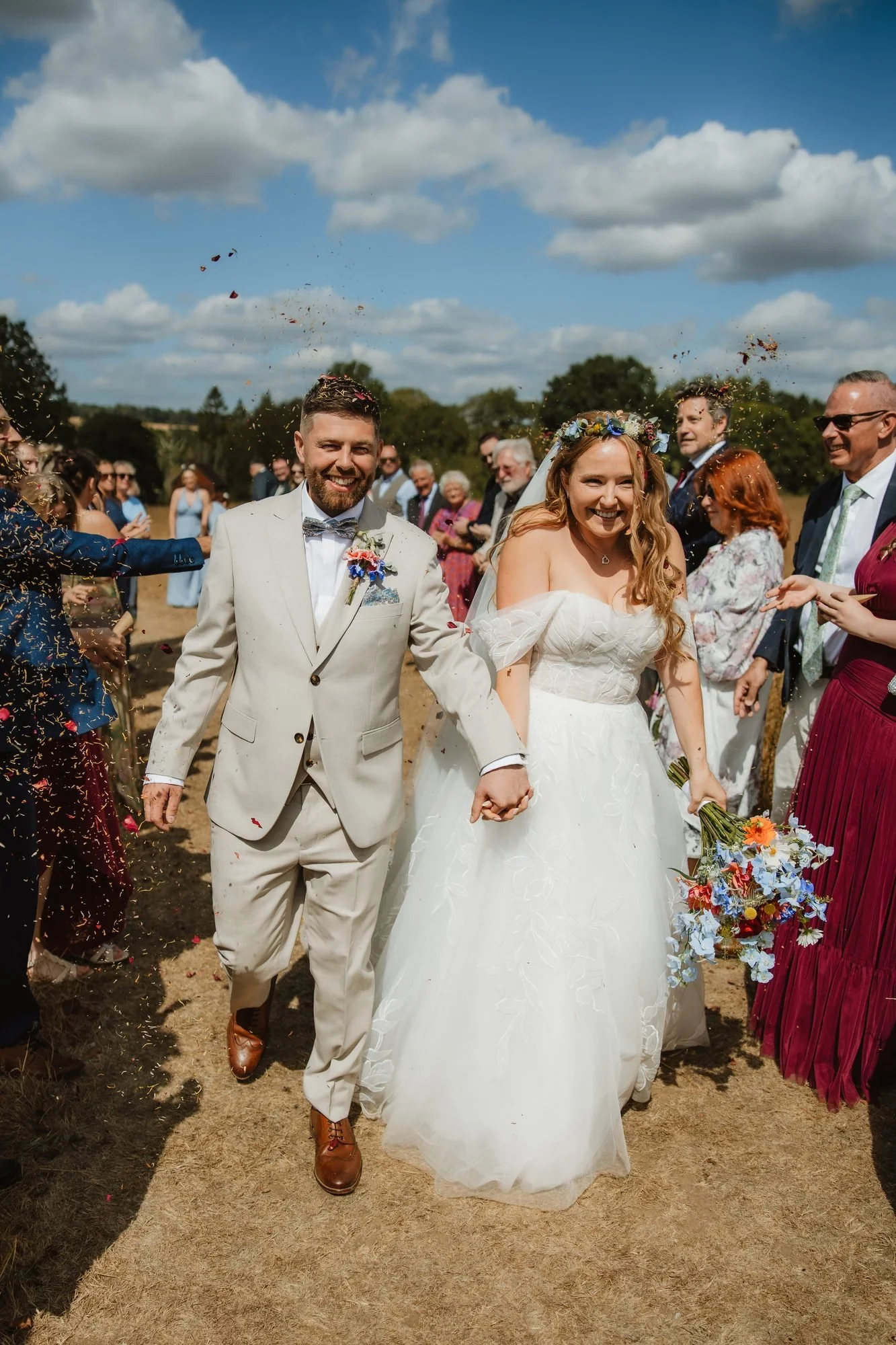Newlyweds walking back down the aisle smiling at an outdoor summer wedding