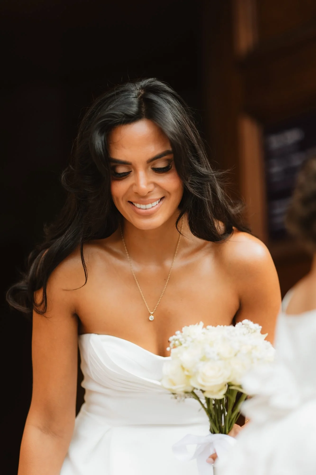 Bridal portrait of a smiling bride holding a bouquet of white roses