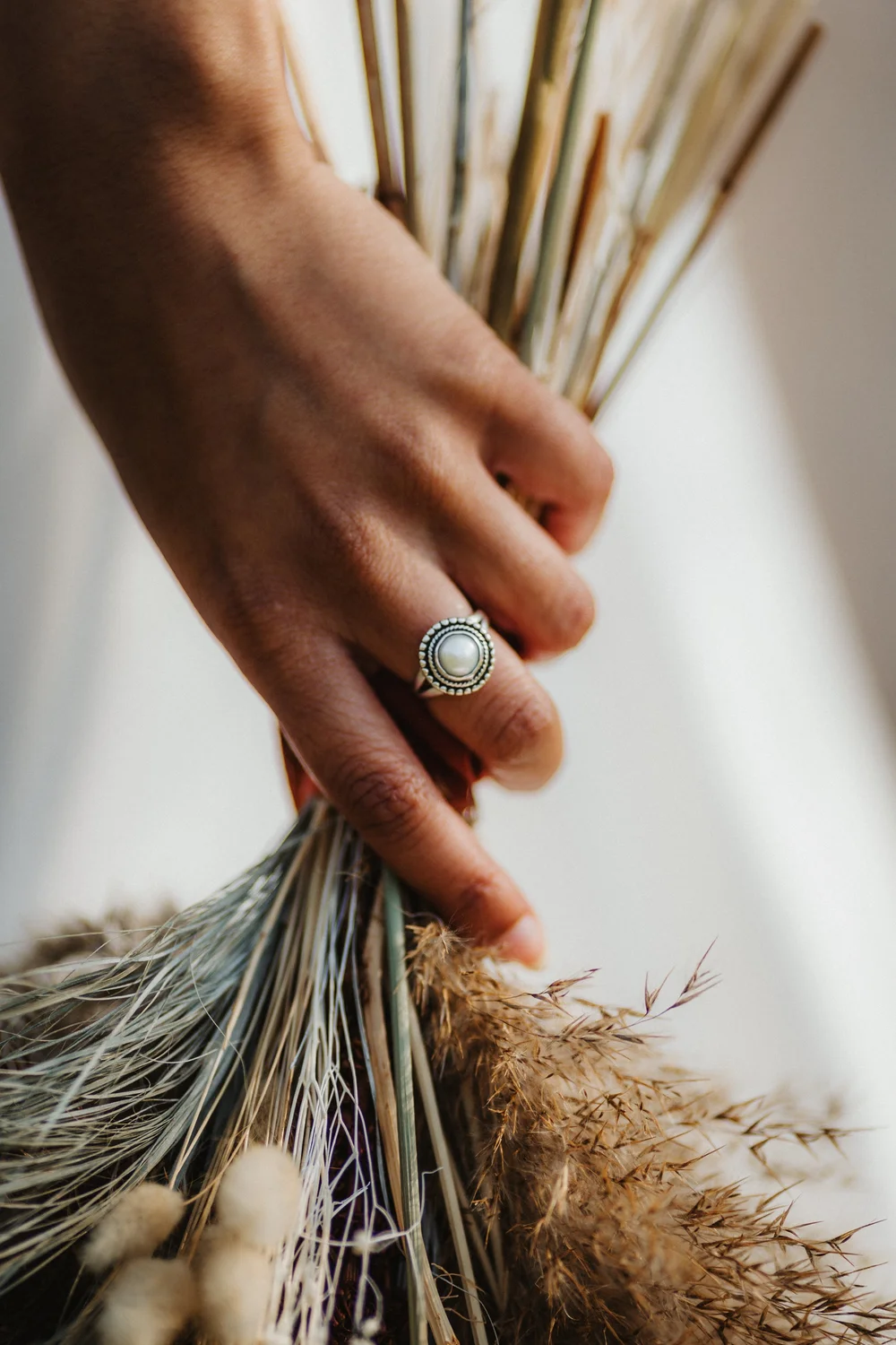 Bride's hand holding a dried flower bouquet