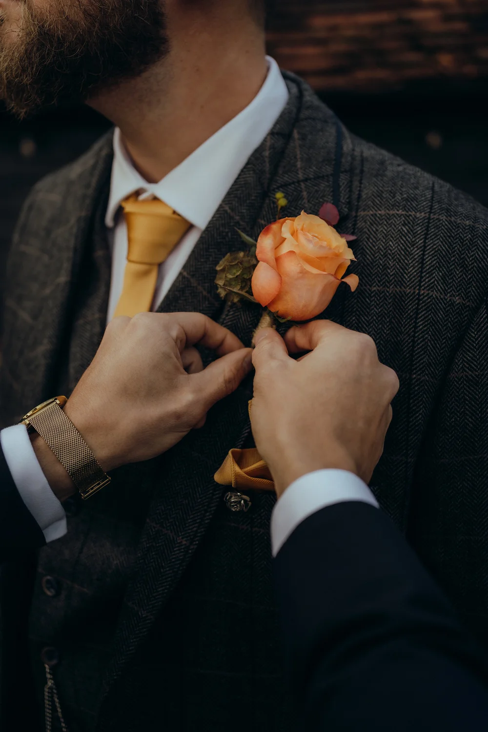 Groom having his buttonhole pinned on