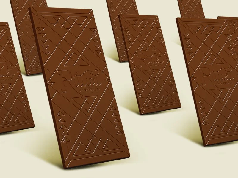 Multiple chocolate bars with geometric patterns and a logo reading 'Ritz' on a white surface.