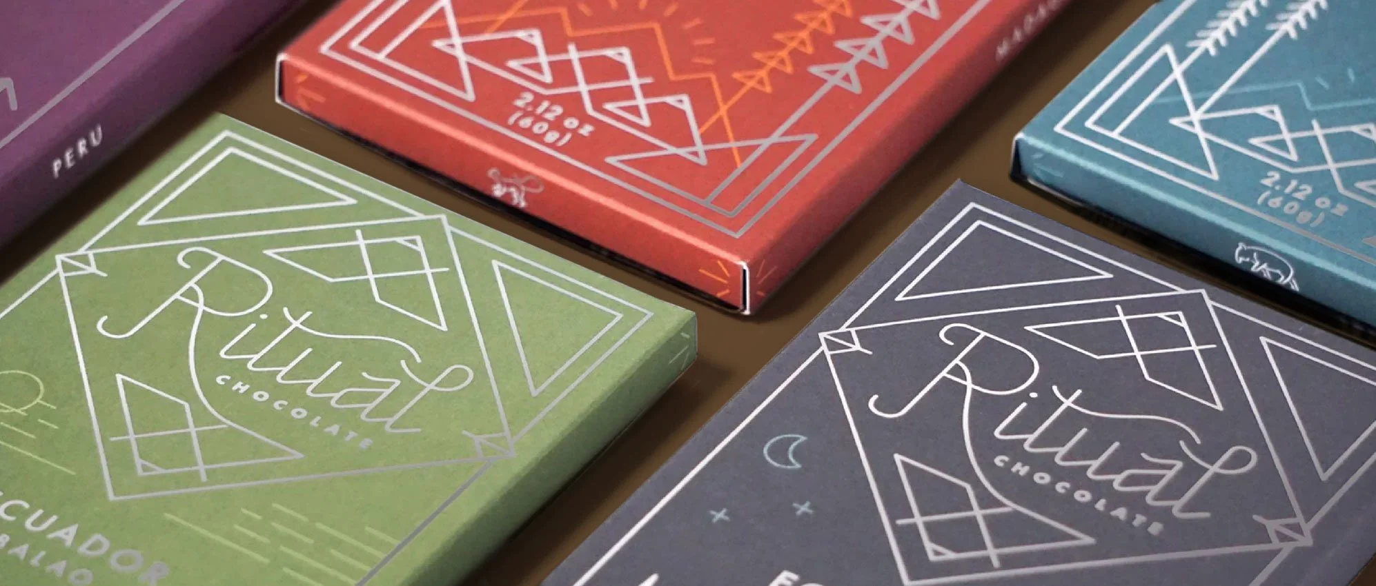 Colorful boxes of Ritual chocolate bars with geometric line art designs and the Ritual logo.