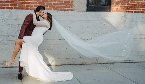 bride in her ivory wedding dress as her wedding veil flies.