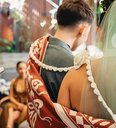 Bride and Groom with a traditional laso around them and a sge colored veil on the brides head.