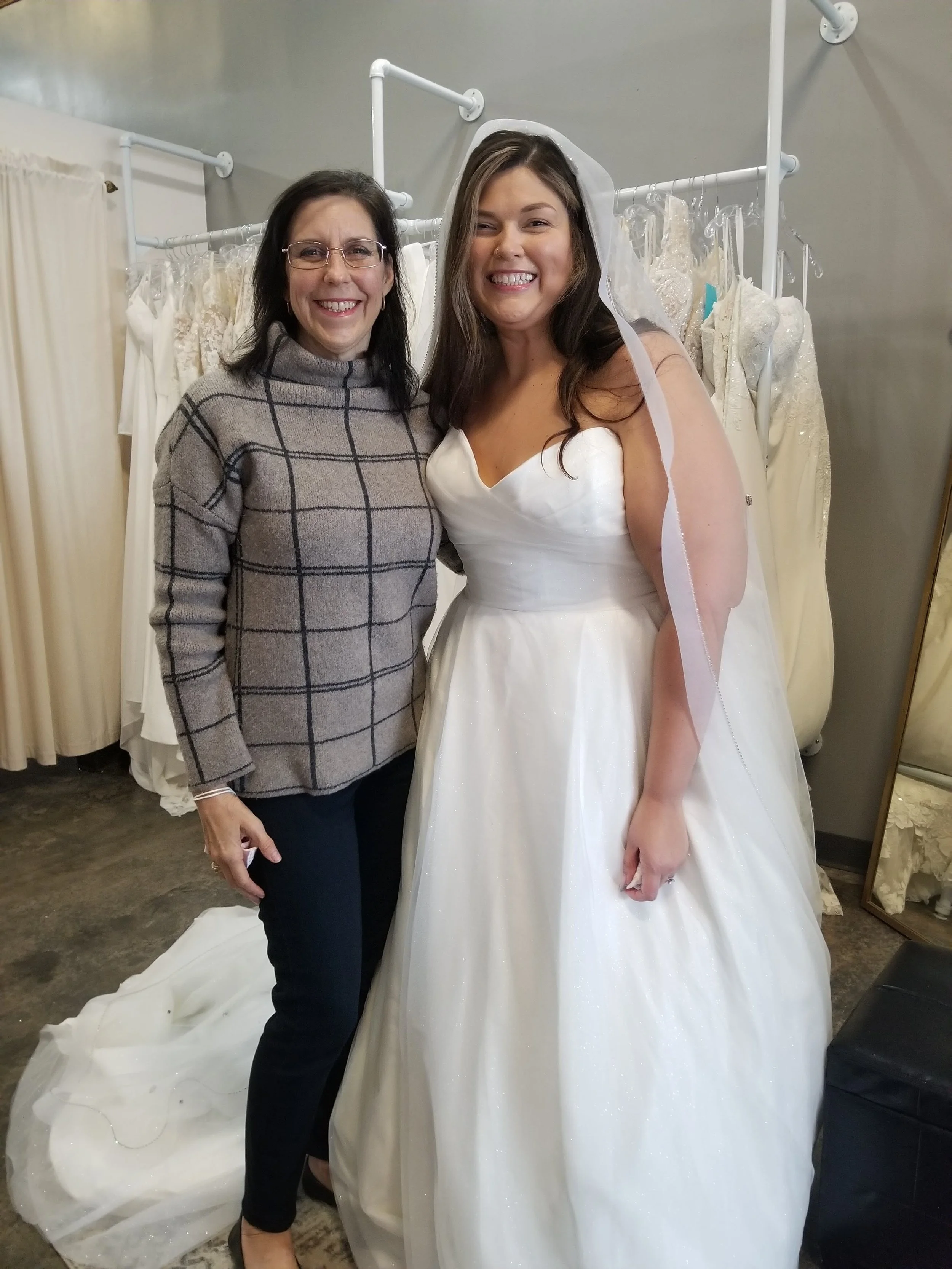 Bridal fashion designer standing next to her bride showing her custom made veil.
