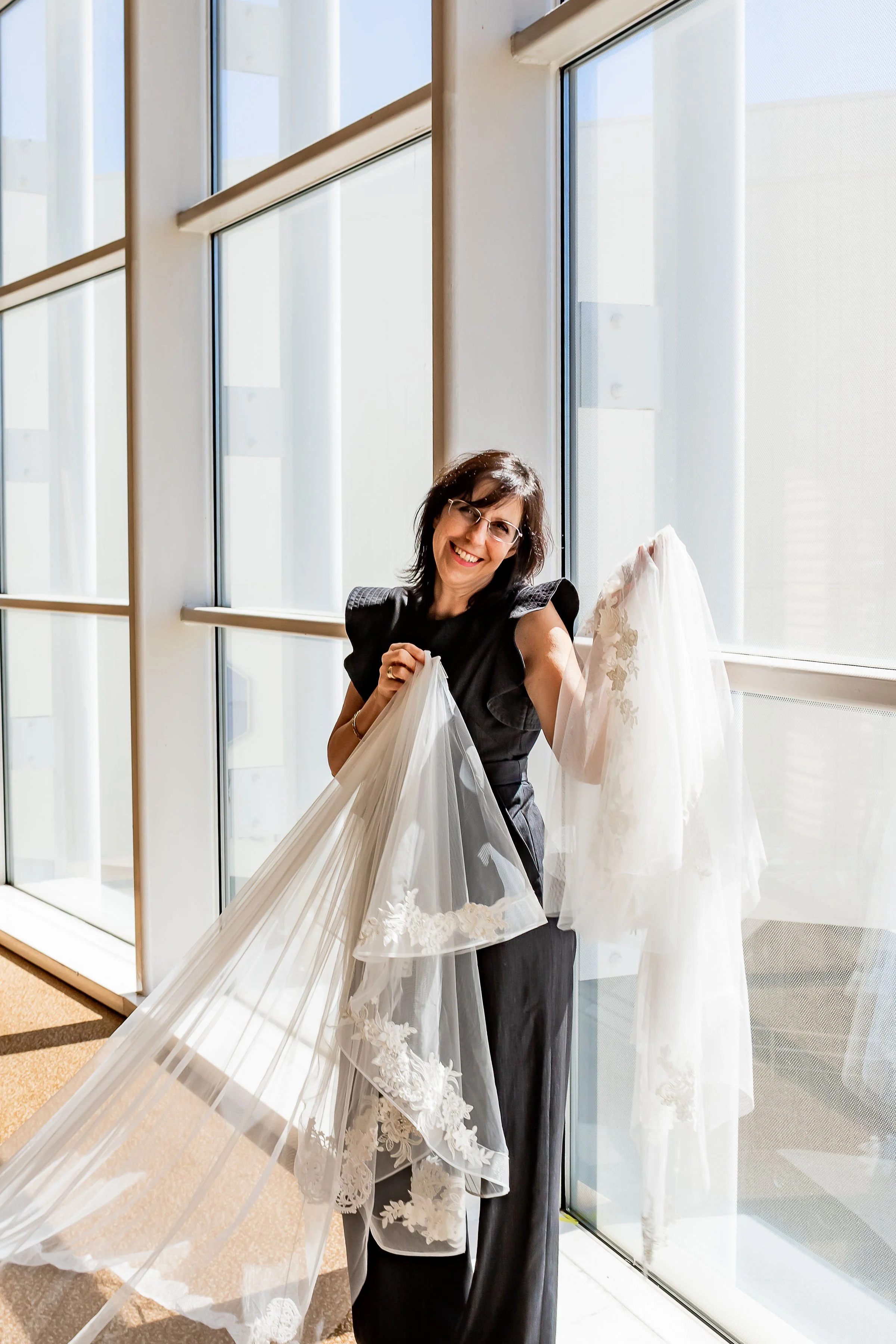 Wedding Veil Designer holding up custom made wedding veils.