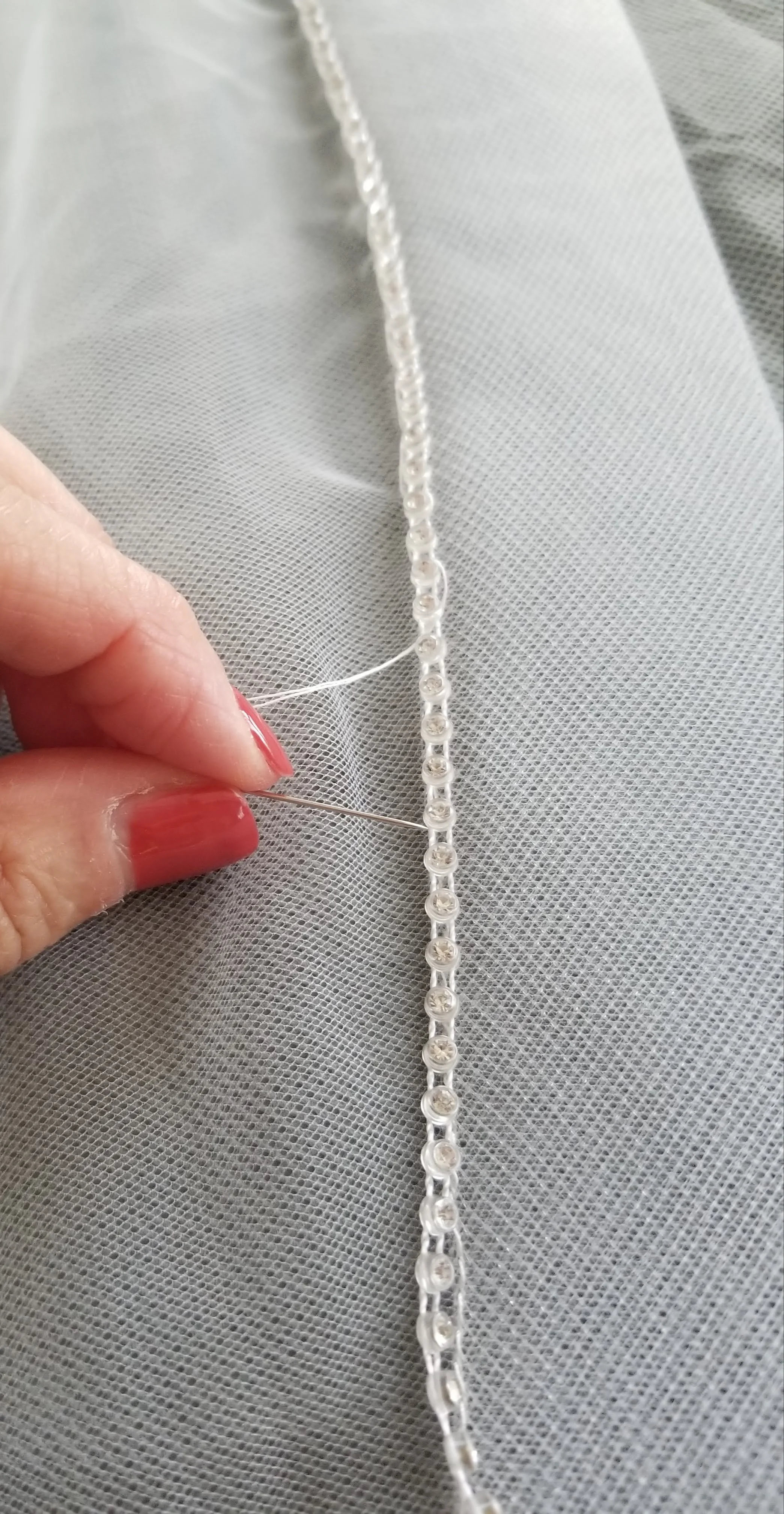 Hand stitch rhinestone trim on veil