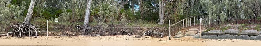 Shoreline of Norfolk Beach of Coochiemudlo Island showing erosion on one side of the path and sand bags on the other.