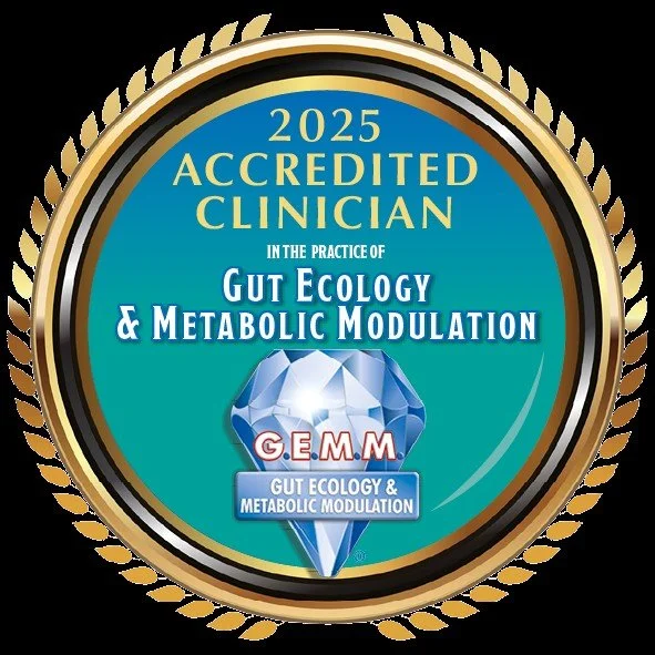 A circular badge with gold and black border, blue interior, and text displaying accreditation for practicing in gut ecology and metabolic modulation in 2025, featuring a diamond graphic with the acronym G.E.M.M.