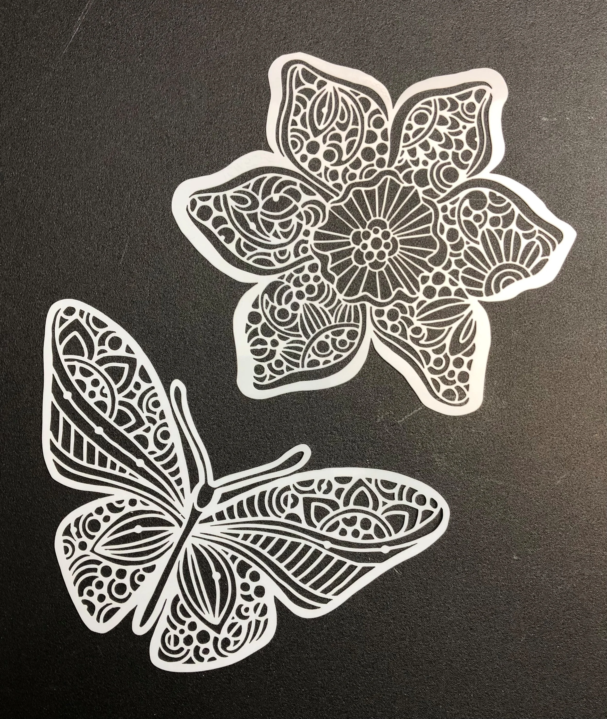 Decorative cut-out paper featuring an intricate design of a butterfly and a flower with detailed patterns.
